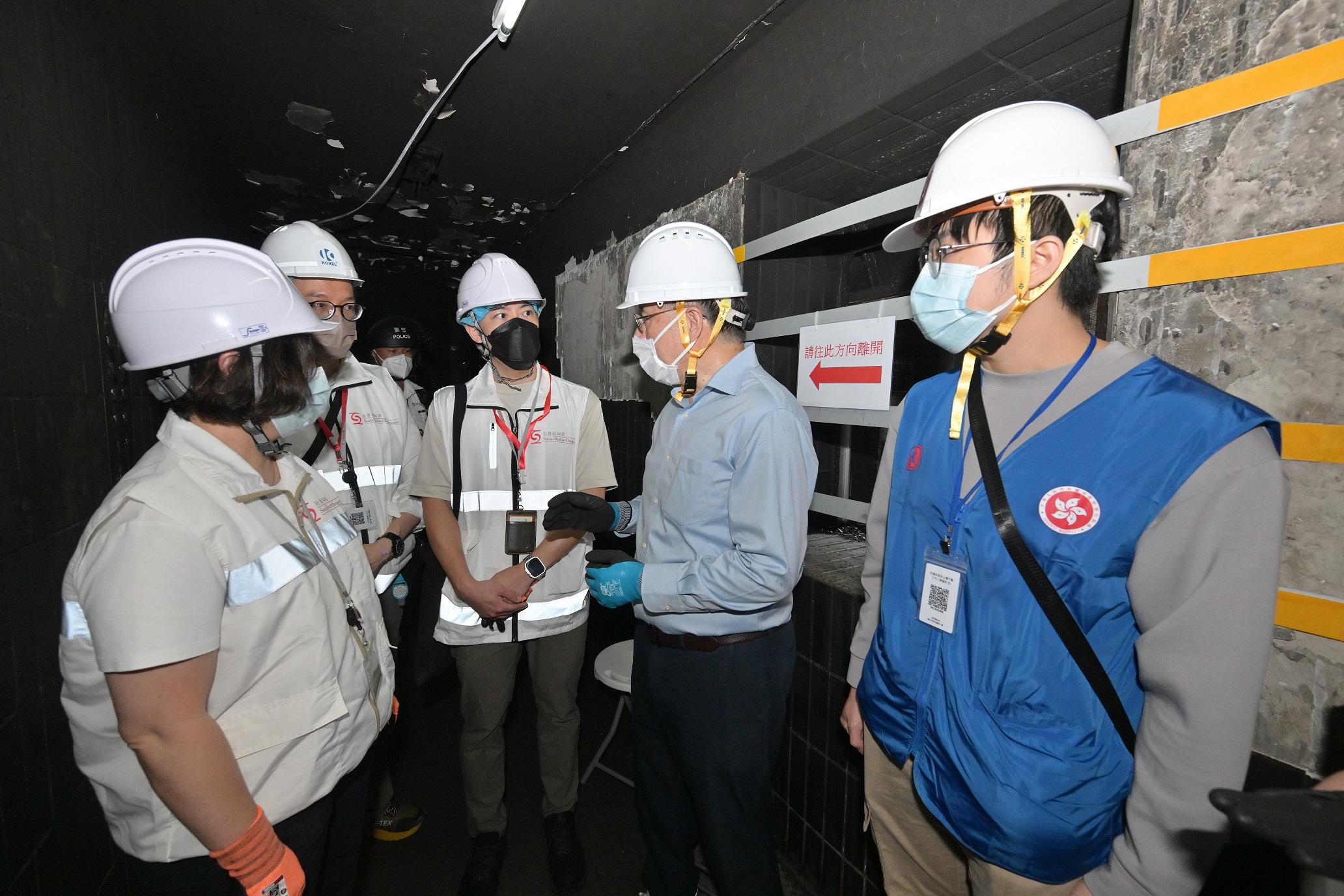 The Deputy Chief Secretary for Administration, Mr Cheuk Wing-hing, today (April 25) went upstairs to middle-zone floors of Wang Cheong House to encourage police officers, fire and ambulance officers, Civil Aid Service members, as well as dedicated teams standing by on different floors. Mobilised civil servants form dedicated teams with social workers and clinical psychologists from the Social Welfare Department, stationed on different floors to provide support to residents returning to their units. Mr Cheuk talked with a resident returning to her unit at Wang Cheong House. She expressed her wish for coming back to her unit again and Mr Cheuk said that her wish was sure to be realised. Photo shows Mr Cheuk (second right) encouraging dedicated teams to continue their good efforts to support residents returning to their units.
