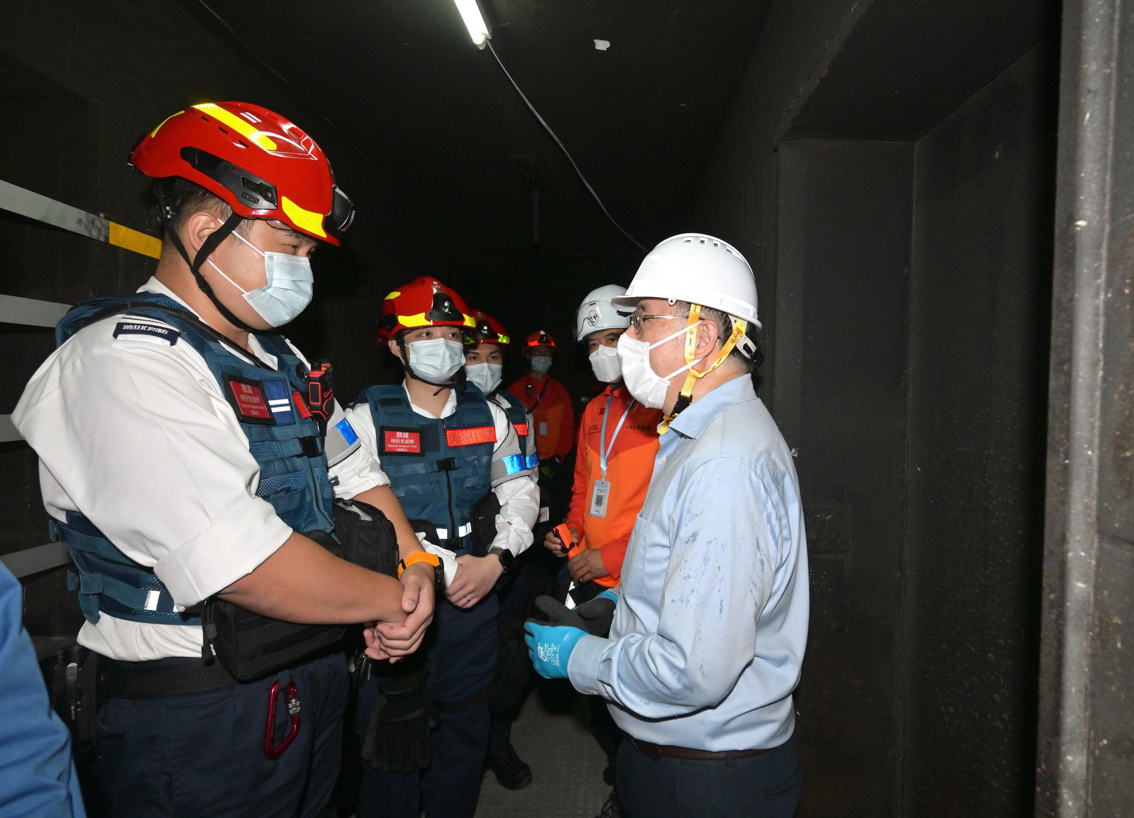 The Deputy Chief Secretary for Administration, Mr Cheuk Wing-hing, today (April 25) went upstairs to middle-zone floors of Wang Cheong House to encourage police officers, fire and ambulance officers, Civil Aid Service members, as well as dedicated teams standing by on different floors. Mobilised civil servants form dedicated teams with social workers and clinical psychologists from the Social Welfare Department, stationed on different floors to provide support to residents returning to their units. Photo shows Mr Cheuk (first right) encouraging fire and ambulance officers standing by on floors.