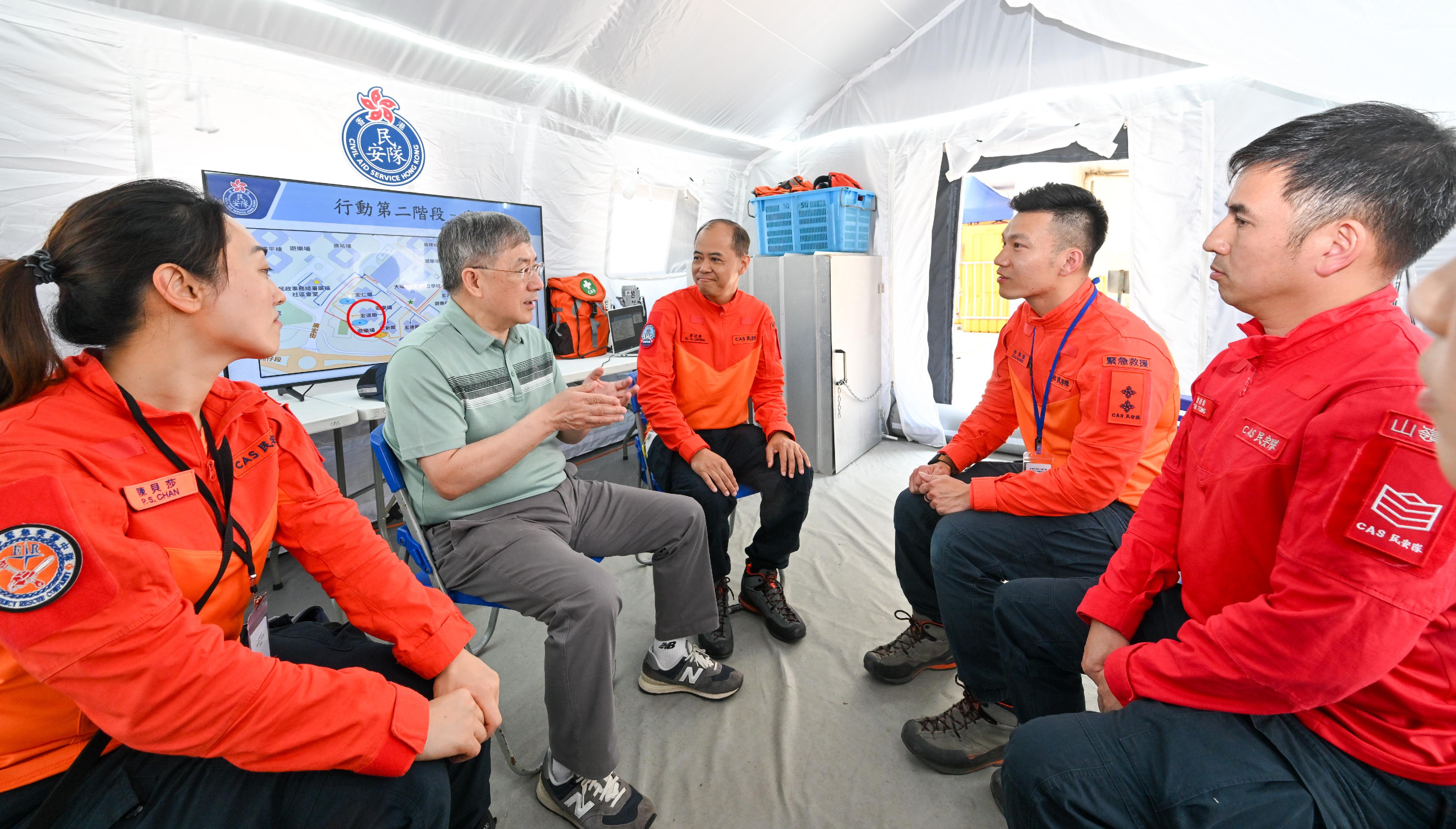 The Deputy Chief Secretary for Administration, Mr Cheuk Wing-hing, today (April 26) inspected the arrangements for Tai Po Wang Fuk Court residents returning to their units. Accompanied by the Chief Staff Officer of the Civil Aid Service (CAS), Mr Leung Kwun-hong, Mr Cheuk visited the CAS Forward Command Post to meet with CAS staff and members. Mr Cheuk thanked all those involved for their enthusiasm and dedication. They are caring in accompanying residents to and from their flats and in and out of their units and made great effort to assist residents in transporting their belongings. All these help ensure the smooth progress of the access arrangements. Photo shows Mr Cheuk (second left) joining an experience sharing session by CAS staff and members on their work in assisting residents returning to their units. Next to Mr Cheuk is the Chief Staff Officer of the CAS, Mr Leung Kwun-hong (centre).