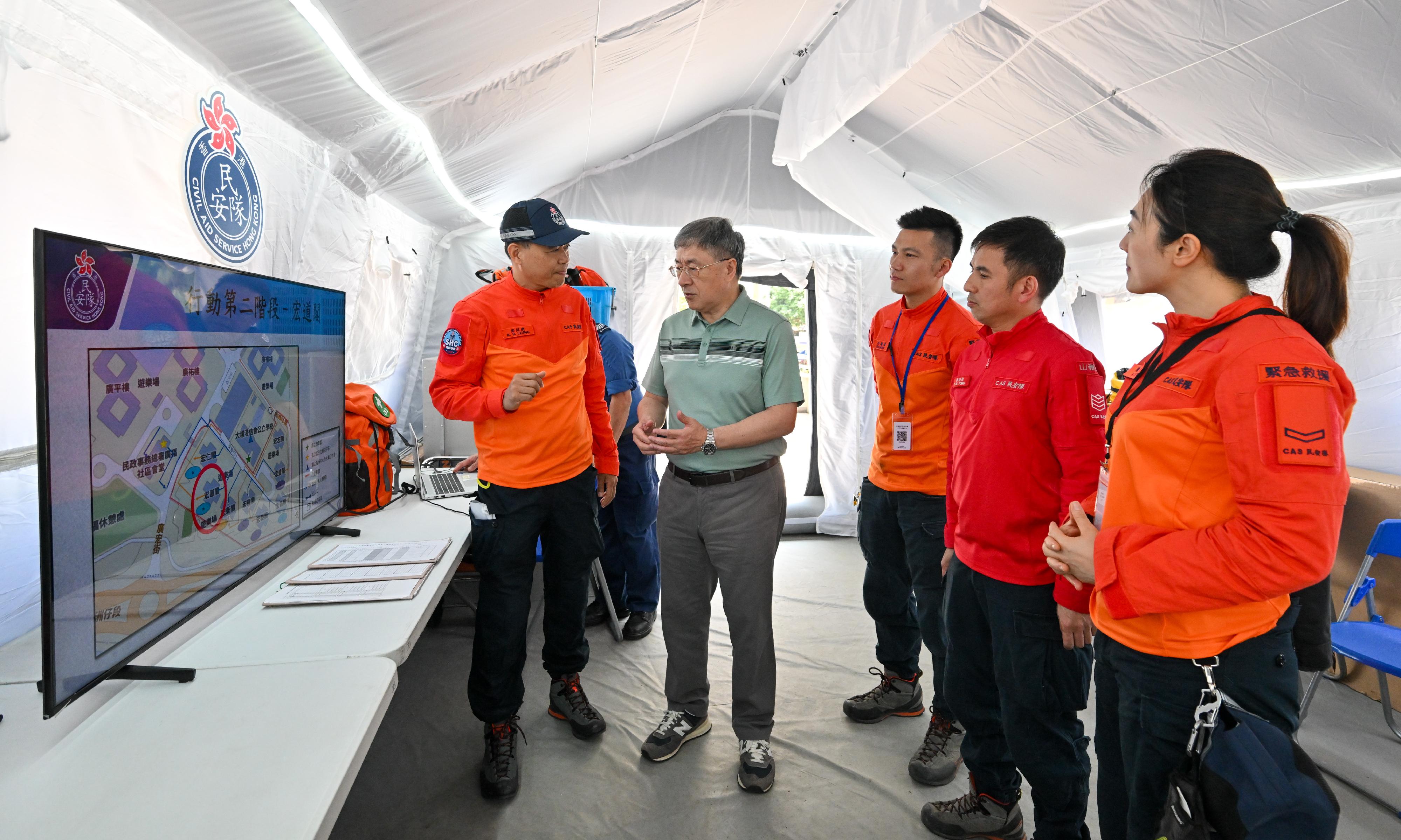 The Deputy Chief Secretary for Administration, Mr Cheuk Wing-hing, today (April 26) inspected the arrangements for Tai Po Wang Fuk Court residents returning to their units. Accompanied by the Chief Staff Officer of the Civil Aid Service (CAS), Mr Leung Kwun-hong, Mr Cheuk visited the CAS Forward Command Post to meet with CAS staff and members. Mr Cheuk thanked all those involved for their enthusiasm and dedication. They are caring in accompanying residents to and from their flats and in and out of their units and made great effort to assist residents in transporting their belongings. All these help ensure the smooth progress of the access arrangements. Photo shows Mr Cheuk (second left) receiving a briefing by the Chief Staff Officer of the CAS, Mr Leung Kwun-hong (first left), on the work and deployment of the CAS in assisting residents returning to their units.