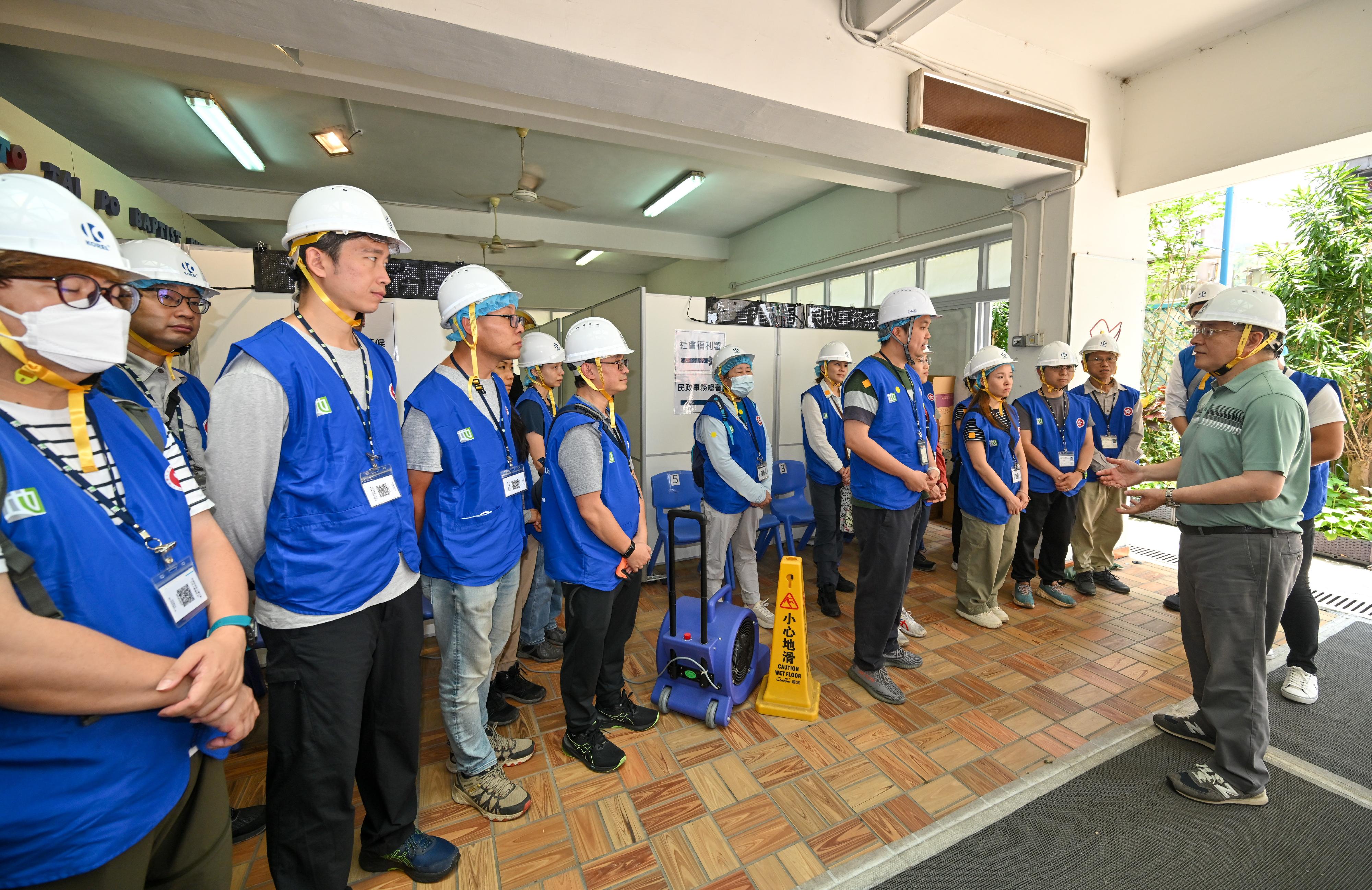 The Deputy Chief Secretary for Administration, Mr Cheuk Wing-hing, today (April 26) inspected the arrangements for Tai Po Wang Fuk Court residents returning to their units. Photo shows Mr Cheuk (first right) encouraging civil servants mobilised from the Lands Department.
