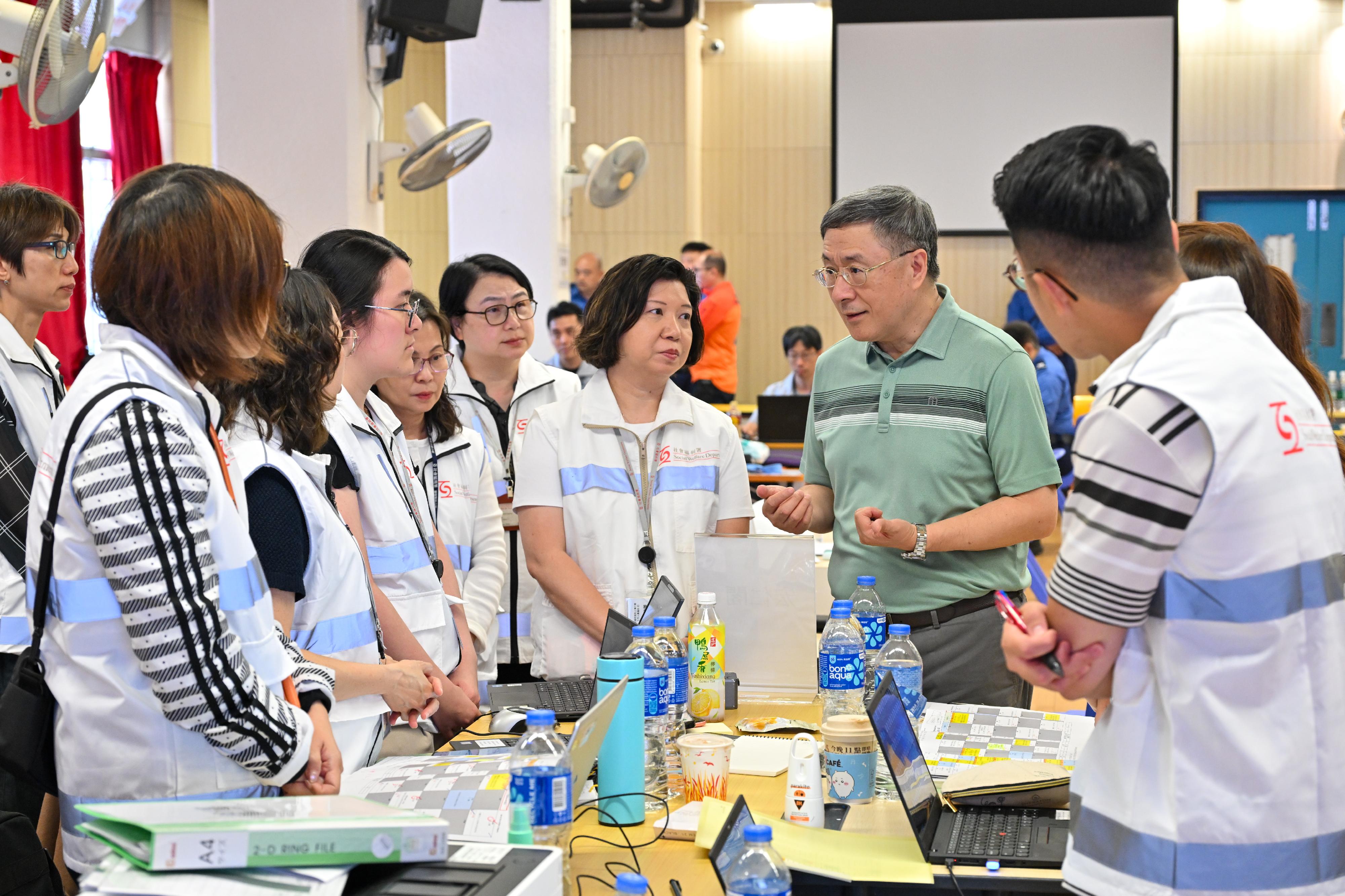 The Deputy Chief Secretary for Administration, Mr Cheuk Wing-hing, today (April 26) inspected the arrangements for residents of Wang Fuk Court in Tai Po returning to their units. At the Joint Command Centre, Mr Cheuk exchanged with staff members of the Social Welfare Department (SWD) to better understand their support for residents returning to their units. The SWD has stepped up support for residents in need, including arranging clinical psychologists and social workers to accompany them throughout the process.Photo shows Mr Cheuk (second right) encouraging staff members of the SWD to continue their good efforts to support residents. Next to Mr Cheuk is the Deputy Director of Social Welfare (Services), Ms Maggie Leung (third right).