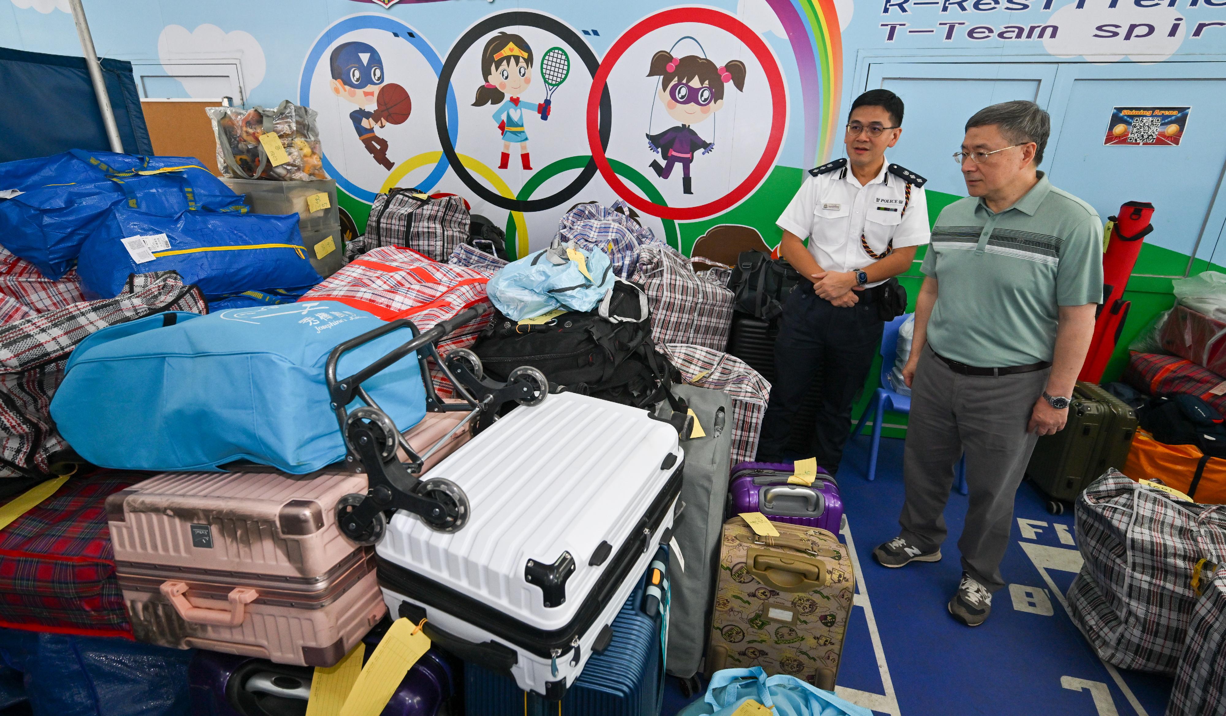The Deputy Chief Secretary for Administration, Mr Cheuk Wing-hing, today (April 26) visited the on-site storage area set up at Tai Po Baptist Public School to get an update of the temporary storage service provided there. Photo shows Mr Cheuk (right) being briefed by the District Commander of Tai Po District, Mr Kong Wing-cheung (left), on the utilisation situation of the storage area.