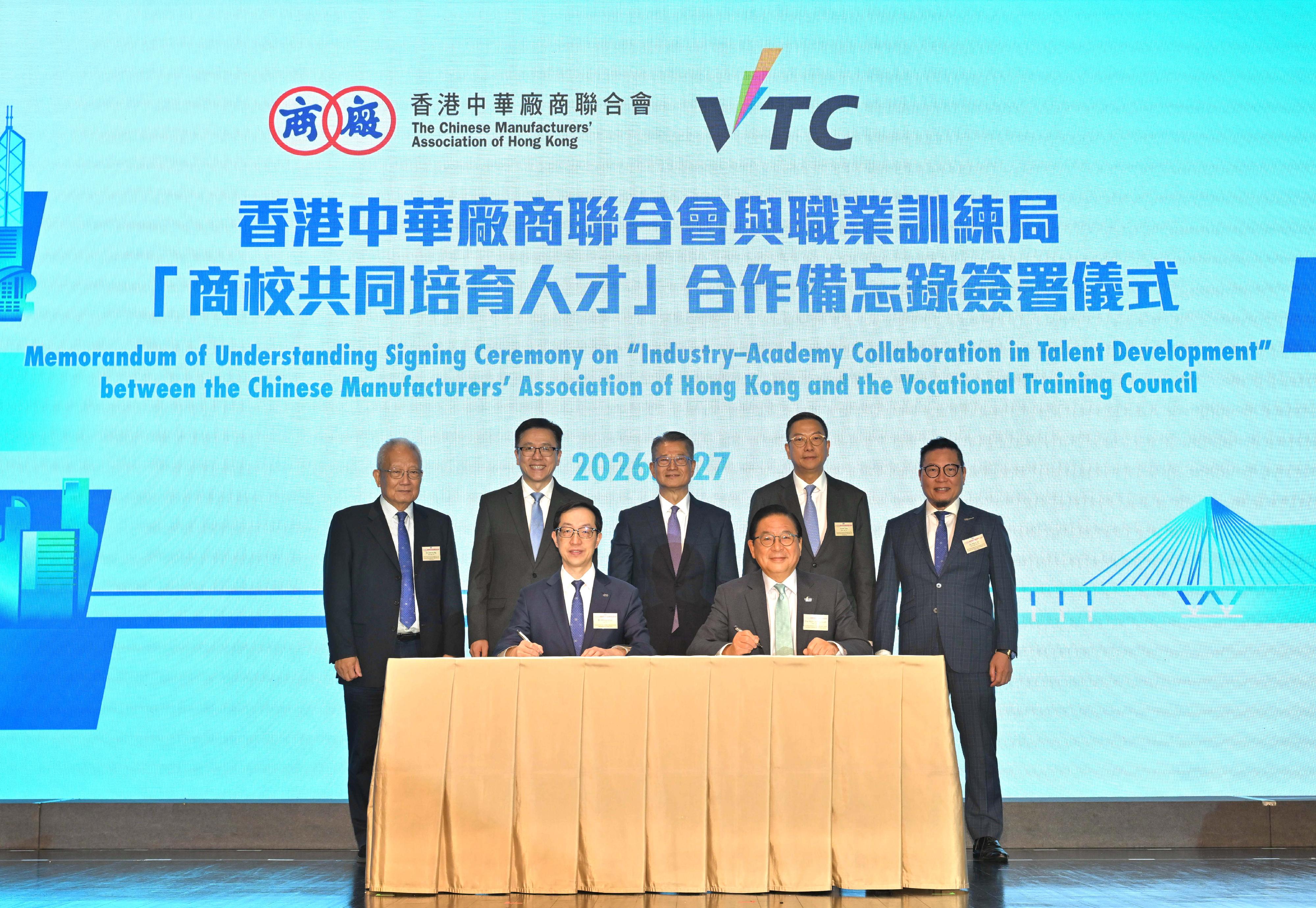 財政司司長陳茂波今日（四月二十七日）出席「十五五」規劃與香港的新機遇高峰論壇。圖示陳茂波（後排中）、創新科技及工業局局長孫東教授（後排左二）和其他嘉賓一同見證香港中華廠商聯合會會長盧金榮博士（前排左）和職業訓練局主席林健鋒（前排右）簽署「商校共同培育人才」合作備忘錄。