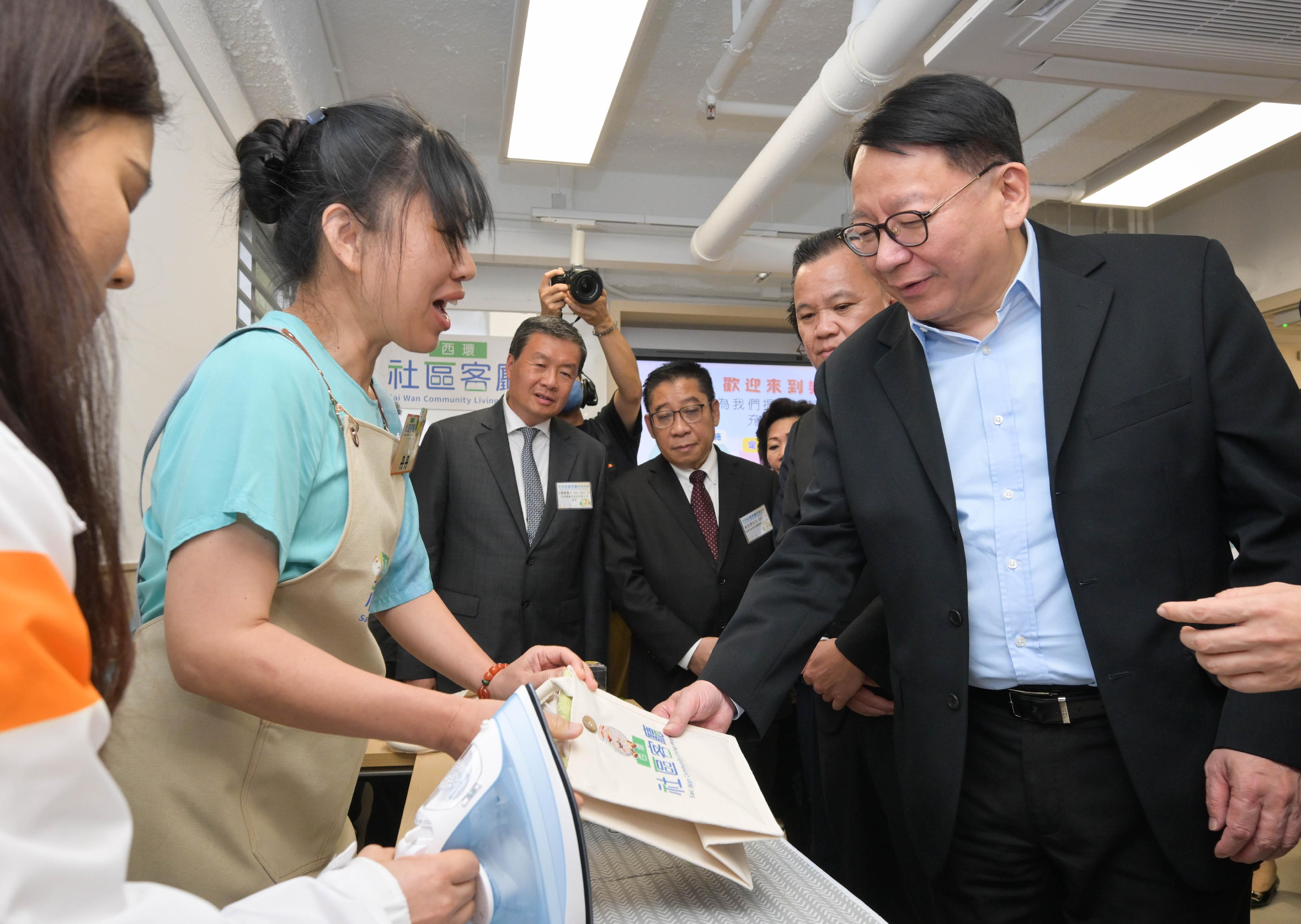 政務司司長陳國基今日（四月二十七日）出席西環社區客廳開幕典禮。圖示陳國基（右一）參觀社區客廳設施，並與用戶交流。
