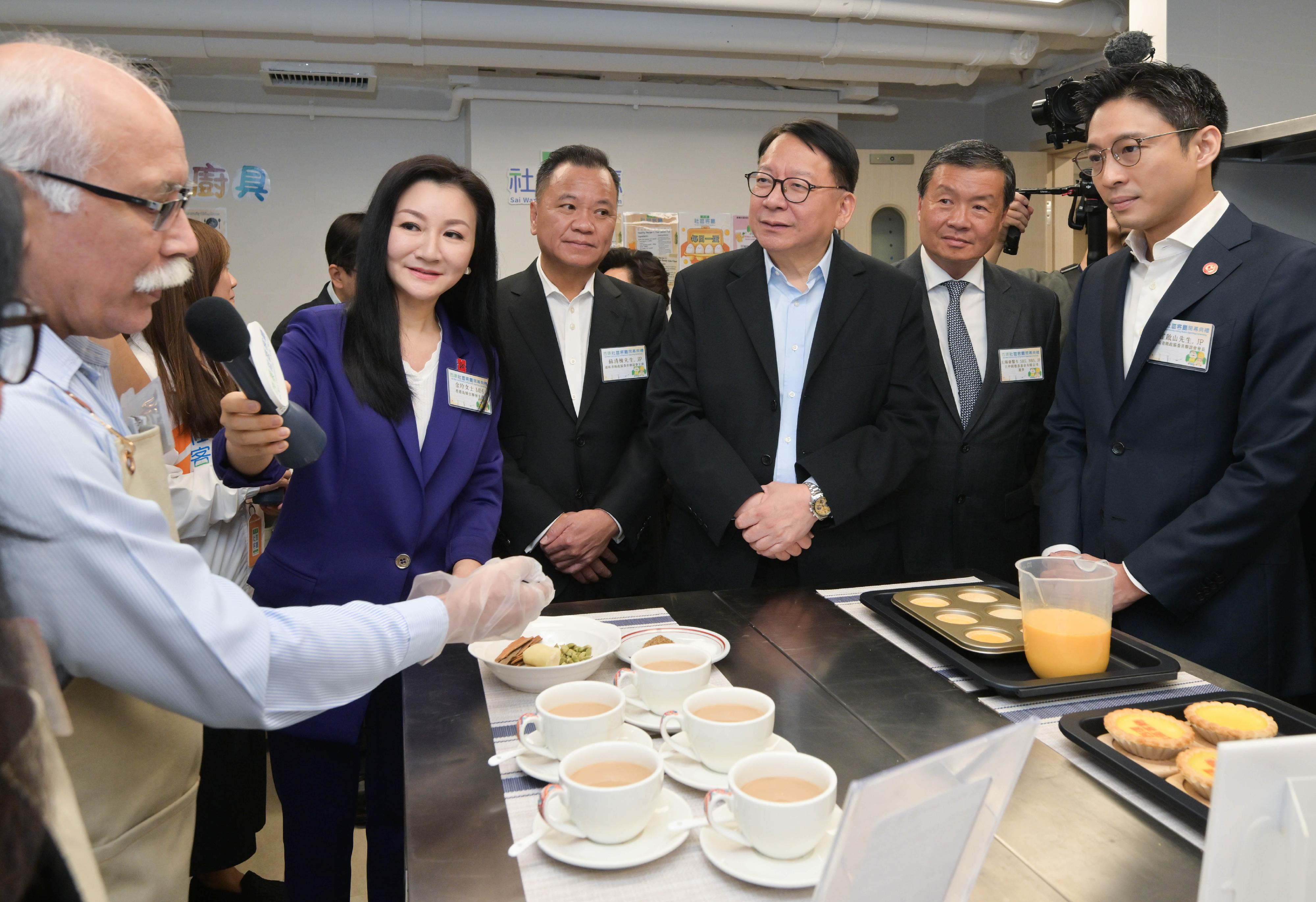 政務司司長陳國基今日（四月二十七日）出席西環社區客廳開幕典禮。圖示陳國基（右三）參觀社區客廳設施，並與用戶交流。

