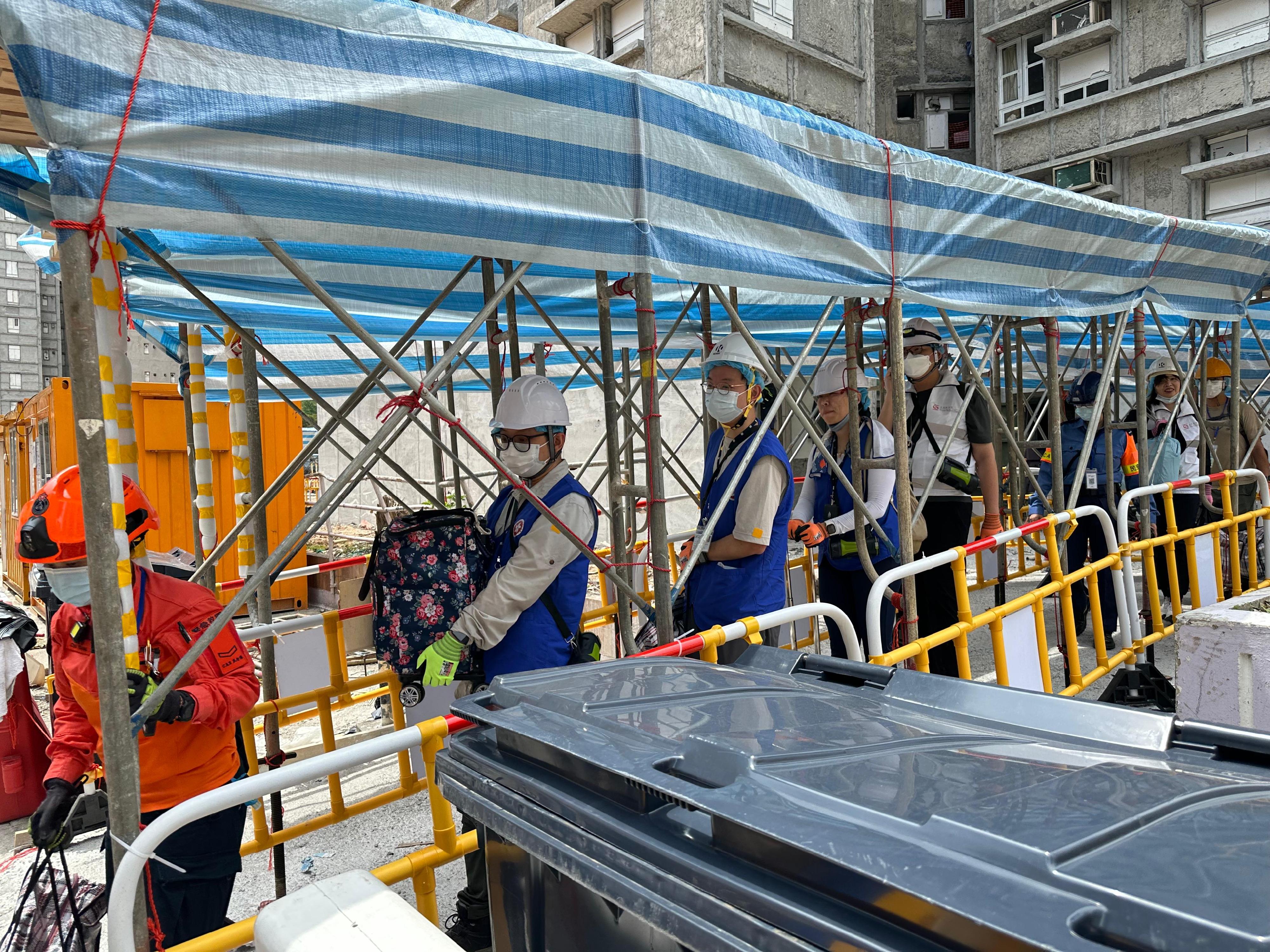 來自地政總署的動員公務員聯同民眾安全服務隊隊員和地區服務及關愛隊伍義工，今日（四月二十七日）協助大埔宏福苑上樓居民搬運物品落樓。
