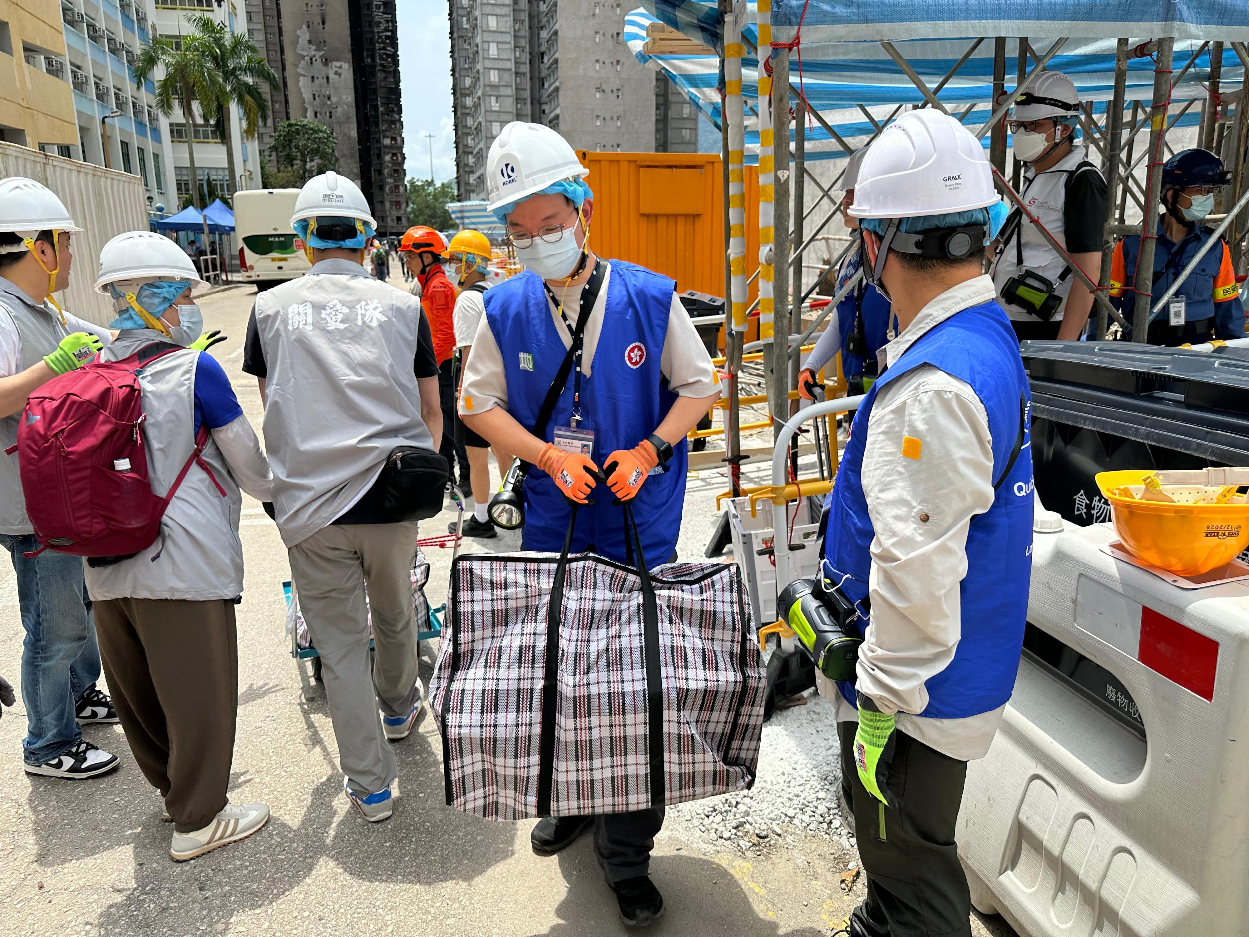 動員公務員、民眾安全服務隊隊員和地區服務及關愛隊伍義工，今日（四月二十七日）同心合力，協助大埔宏福苑上樓居民搬運物品。

