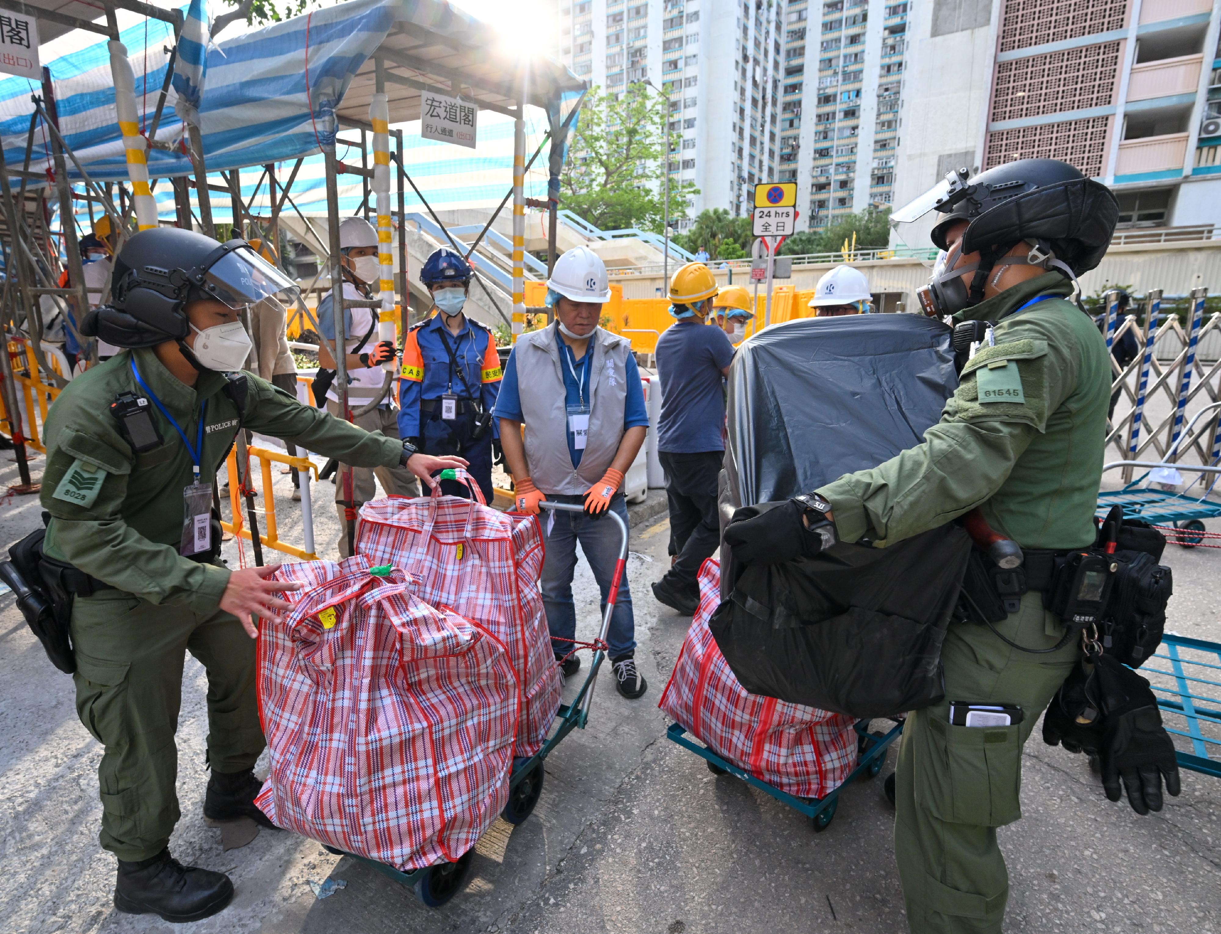 Each day, the Government deploys over 1 000 personnel from various departments to fully support residents returning to their units. Photo shows police officers assisting Wang Tao House residents in moving their belongings.
