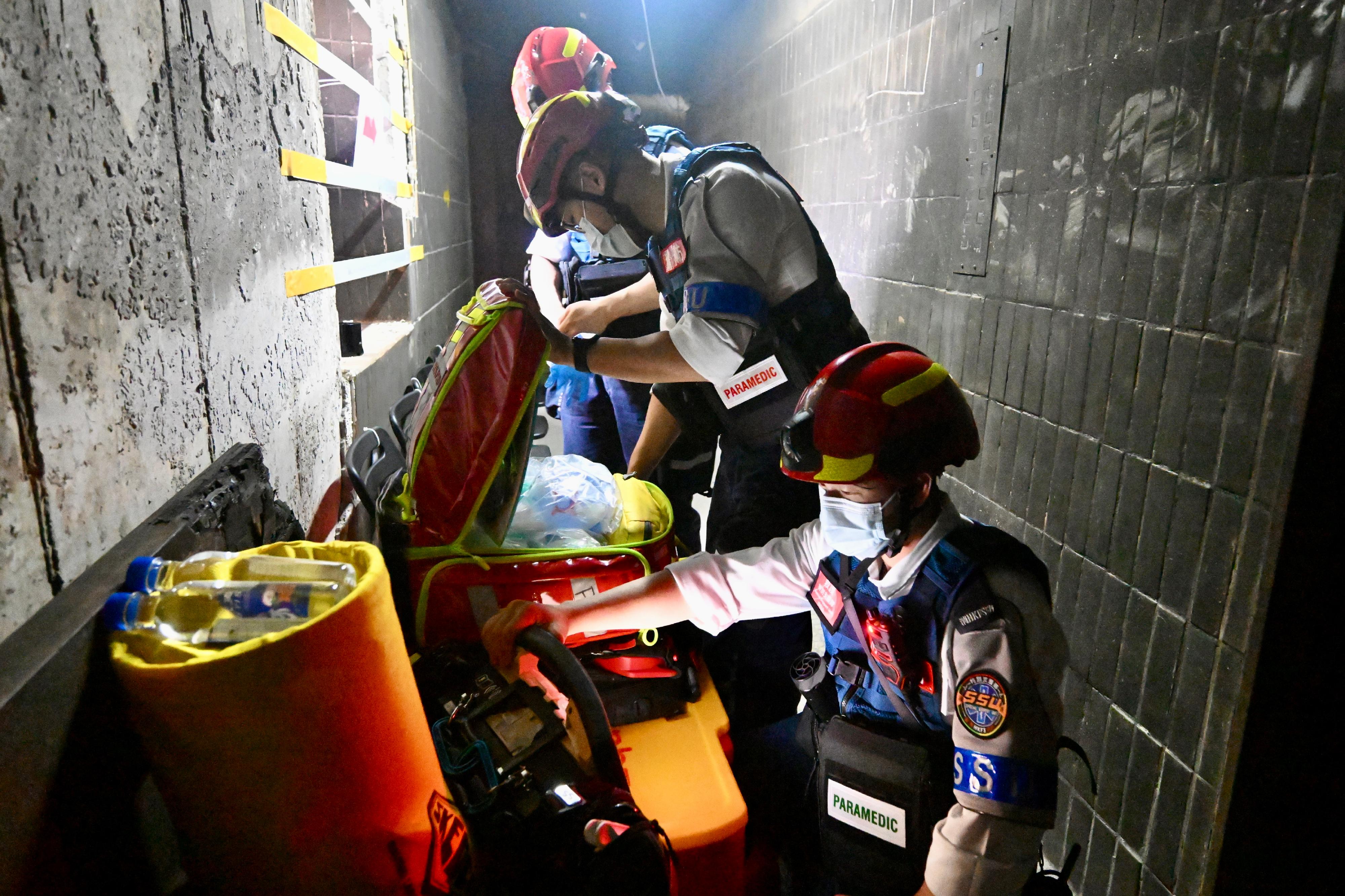 Fire and ambulance officers are stationed on different floors, providing on-site emergency and medical services to residents of Wang Fuk Court returning to their units.