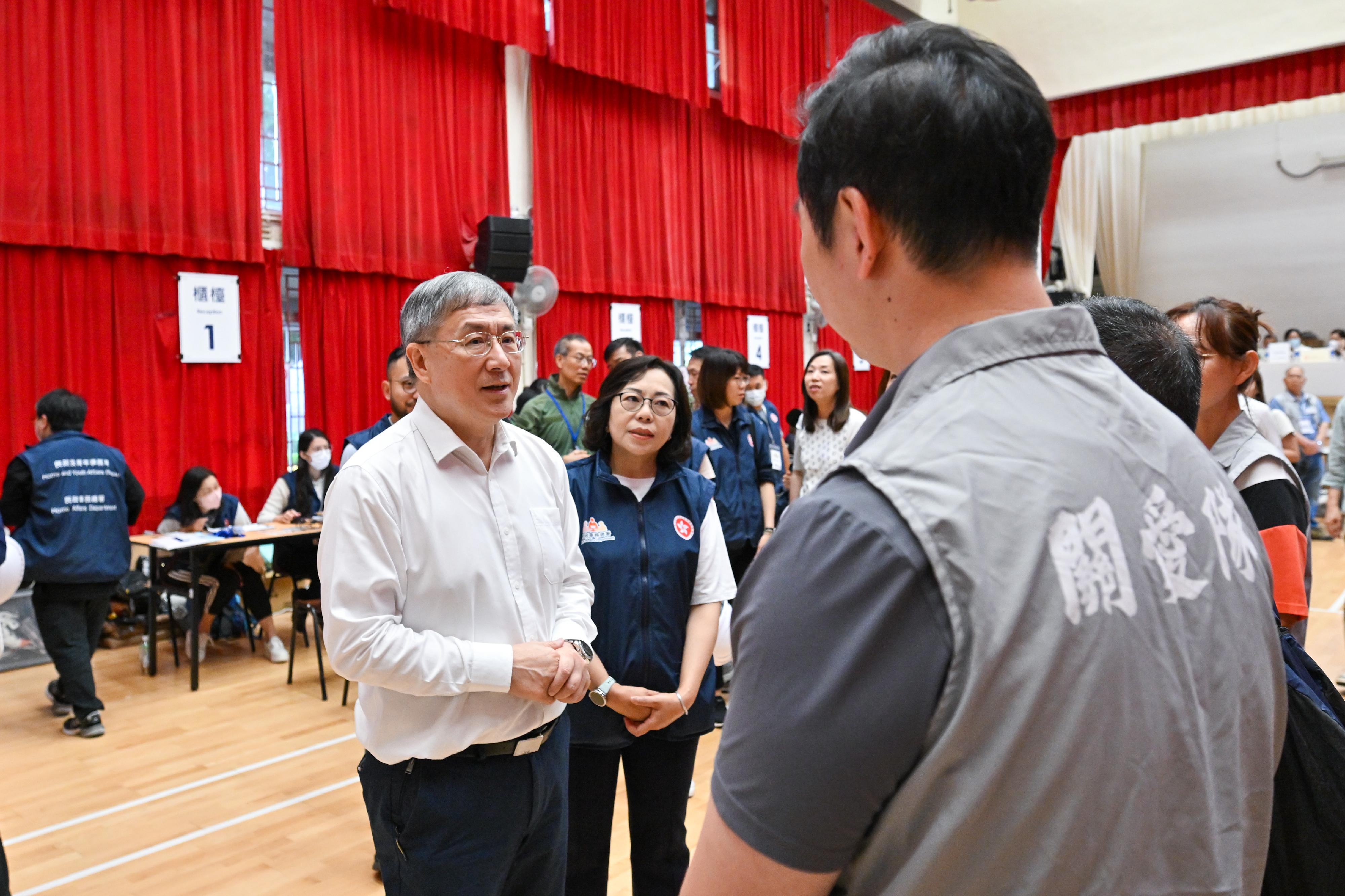 政務司副司長卓永興(左一)和民政及青年事務局局長麥美娟(左二)今日(四月二十九日)到大埔廣福社區會堂視察,與地區服務及關愛隊伍(關愛隊)義工交流。
關愛隊協助向上樓的居民派發防護及照明裝備,包括附有頭套的安全帽、防刮手套、口罩,消毒清潔安全帽及手電筒以供重複使用,幫忙照顧在等候區的陪同人士,準備手推車協助居民執拾後運送物品前往居民等候區或各個乘車處。