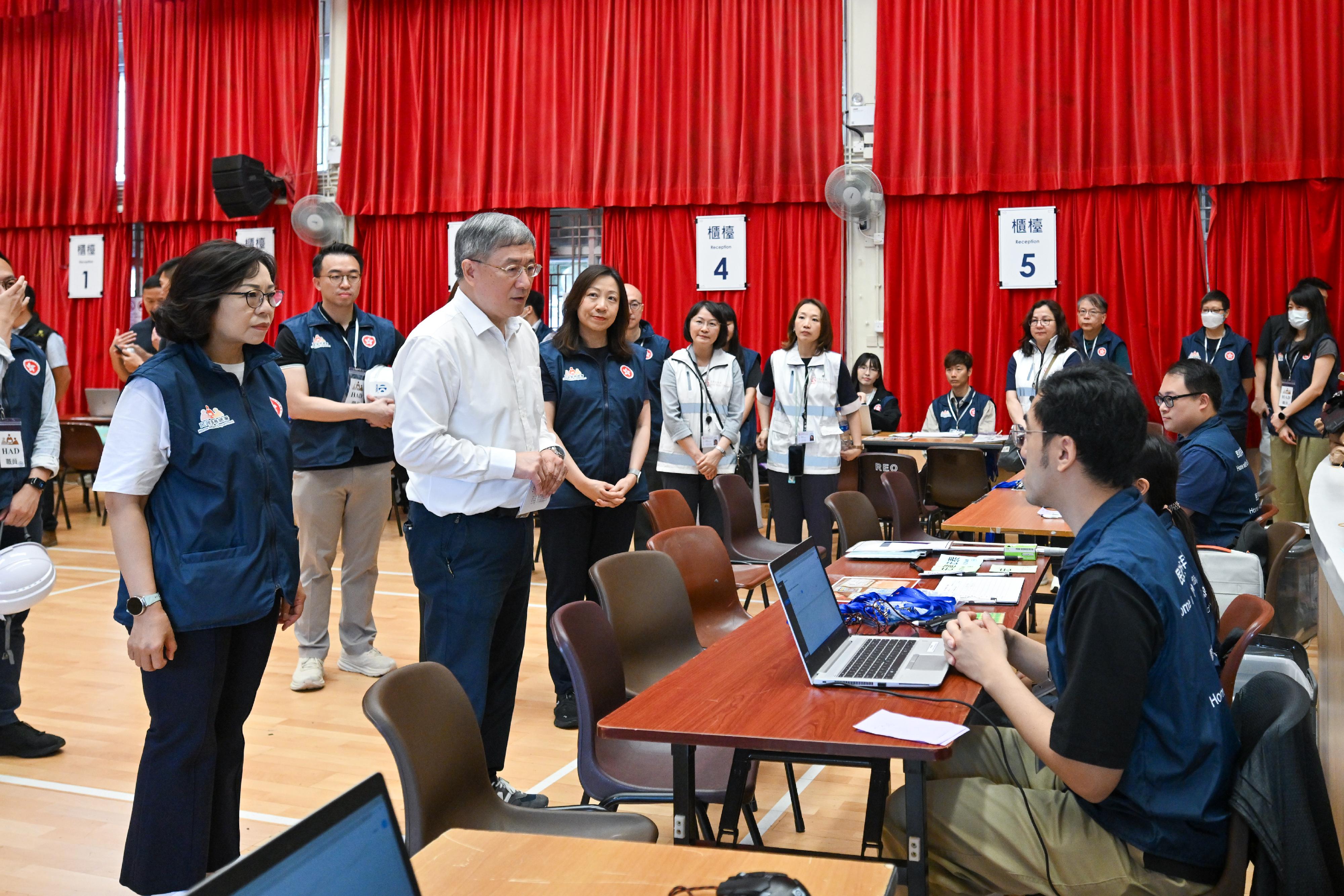The Deputy Chief Secretary for Administration, Mr Cheuk Wing-hing, and the Secretary for Home and Youth Affairs, Miss Alice Mak, today (April 29) visited Kwong Fuk Community Hall in Tai Po to observe the operation of the registration centre after several days of operation. Pre-registered persons of the households are accompanied by social workers to complete registration at the Community Hall. The Home Affairs Department (HAD) is responsible for registering residents returning to their units, including verifying identity documents to ensure they match pre-registered information, preparing identification badges for residents and their accompanying relatives and friends, distributing hygiene and personal items, and matching residents with supporting staff. Photo shows Mr Cheuk (second left) and Miss Mak (first left) encouraging HAD staff at the registration centre to continue their efforts in fully supporting residents returning to their units. Looking on is the Director of Home Affairs, Ms Priscilla To (third left).