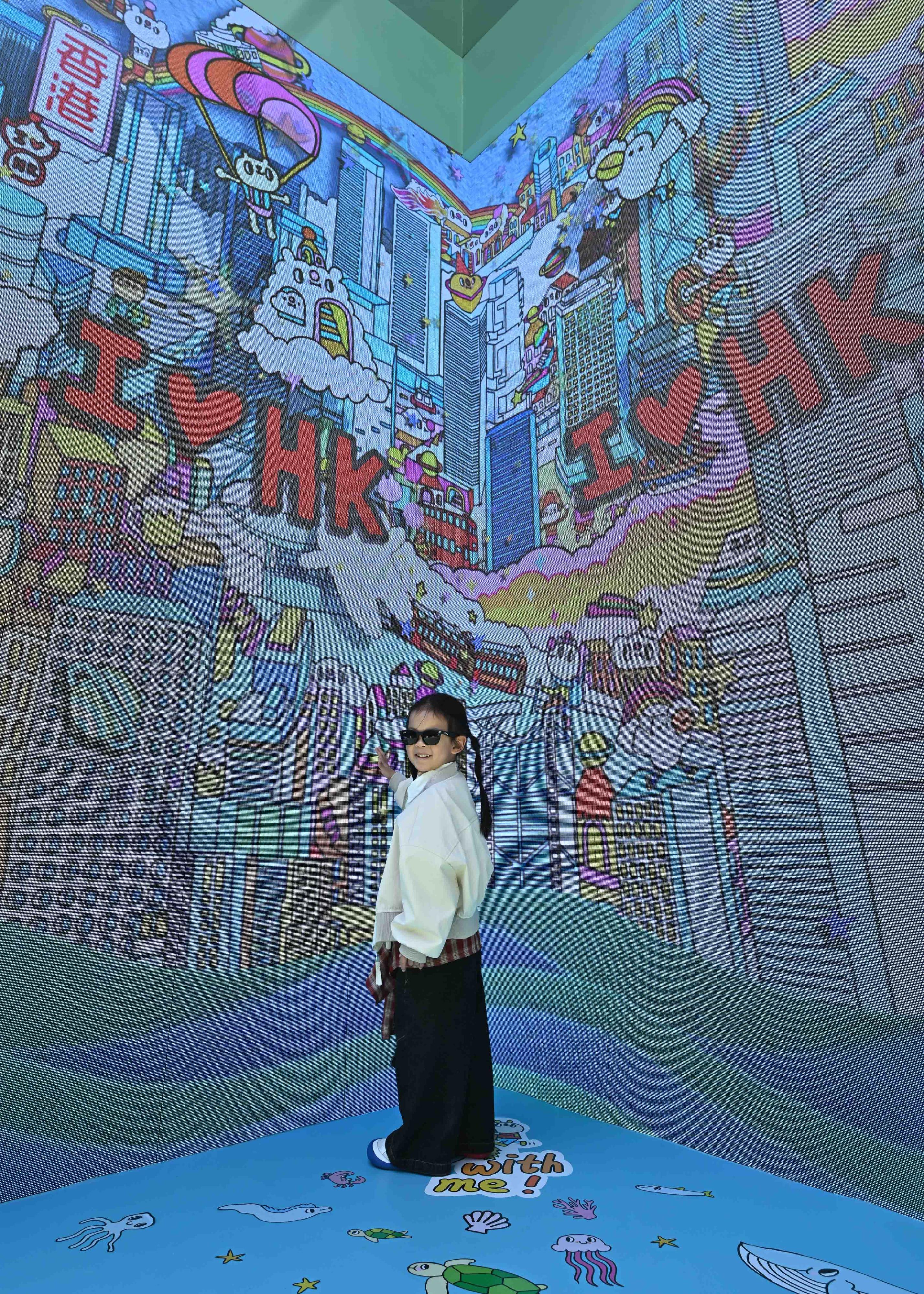 The "Immersive Hong Kong" roving exhibition, which showcases the diversity and latest developments of Hong Kong through interactive art technology, opened in Wuhan, Hubei Province, today (April 30). The exhibition invites visitors from Wuhan and across Hubei Province to explore the unique opportunities and potential for tourism, education, business and investment in Hong Kong. Photo shows a photo corner featuring illustration works of Hong Kong artist Messy Desk (Jane Lee) at the exhibition.