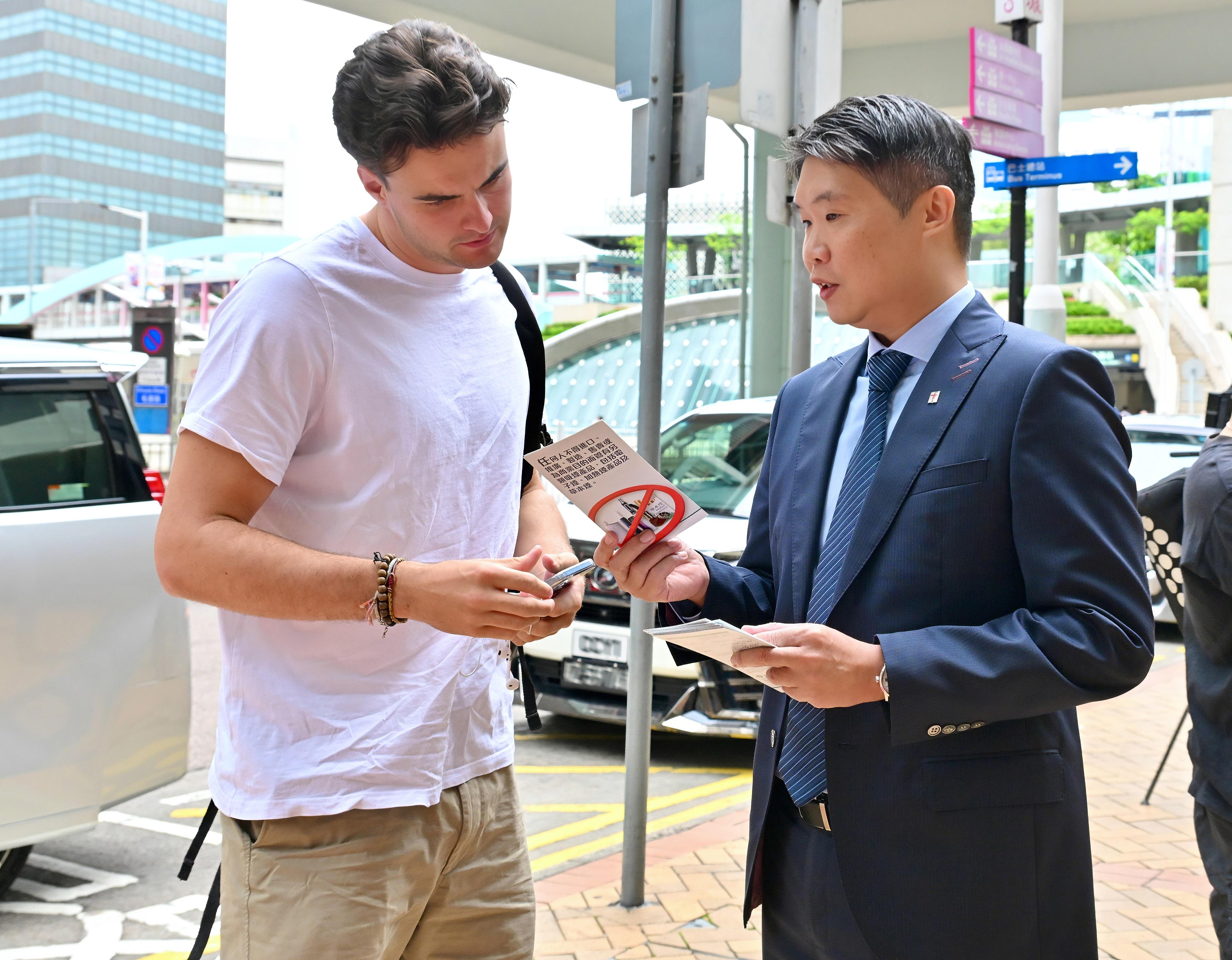 《2025年控煙法例（修訂）條例》下禁止在公眾地方管有電子煙煙彈、加熱煙煙支等指明另類吸煙產品的規定今日（四月三十日）生效。圖示衞生署控煙酒辦公室主任林民聰醫生於金鐘向市民及旅客派傳單，宣傳有關禁令。