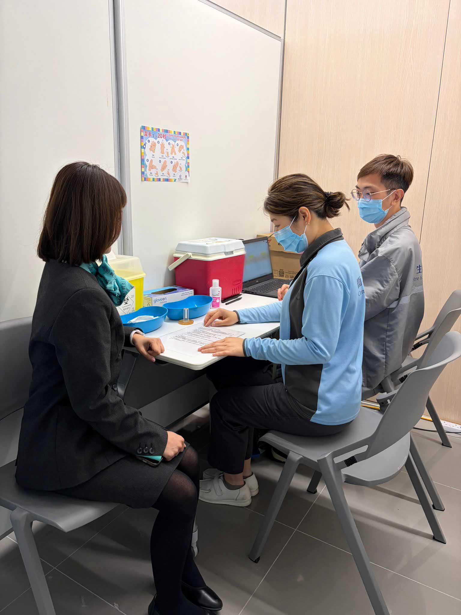 衞生署衞生防護中心（中心）今日（四月三十日）繼續在機場為合資格機場員工免費接種麻疹疫苗，以加強機場社區的群體免疫力。圖示中心職員為機場員工於接種疫苗前講解須知。 