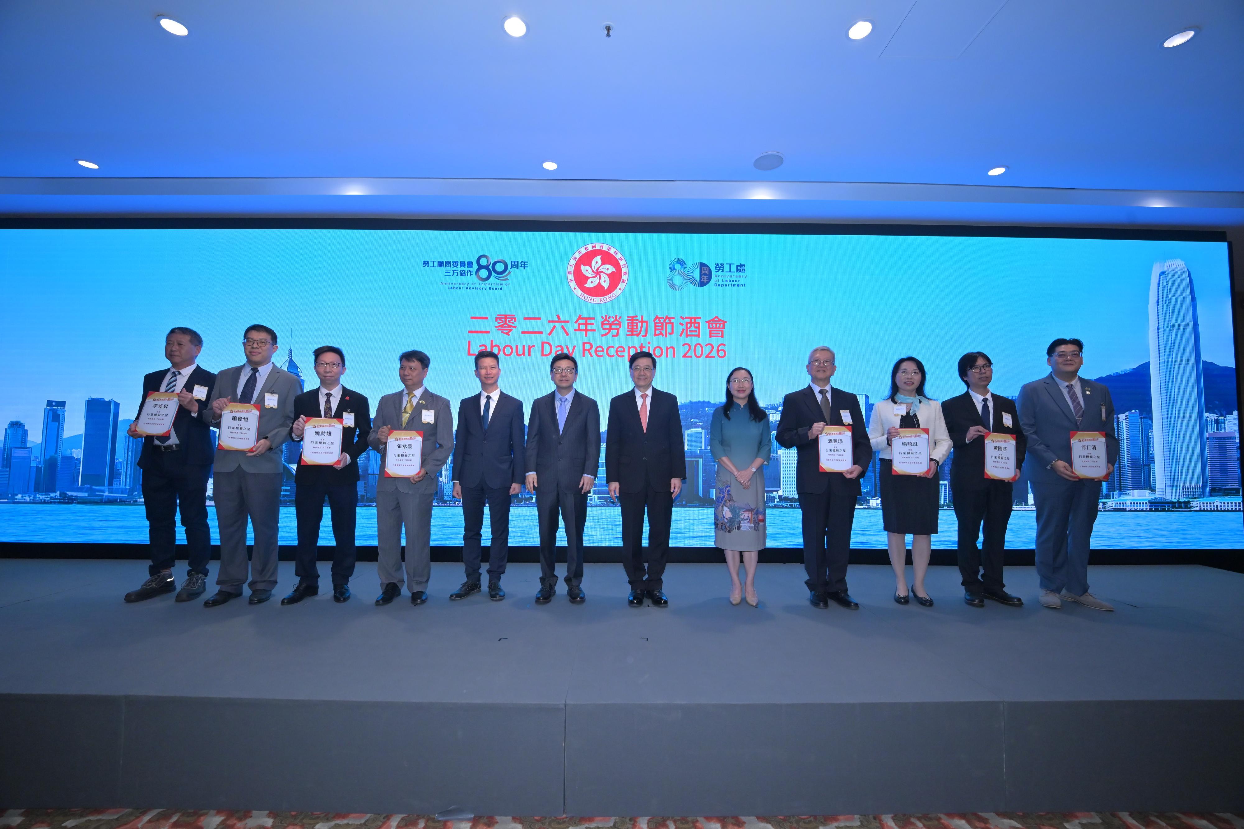行政長官李家超今日（四月三十日）出席二零二六年勞動節酒會。圖示李家超（右六）、勞工及福利局局長孫玉菡（左六）、勞工及福利局常任秘書長劉焱（右五）和勞工處處長許澤森（左五）與2026年行業模範之星得獎者在酒會合照。