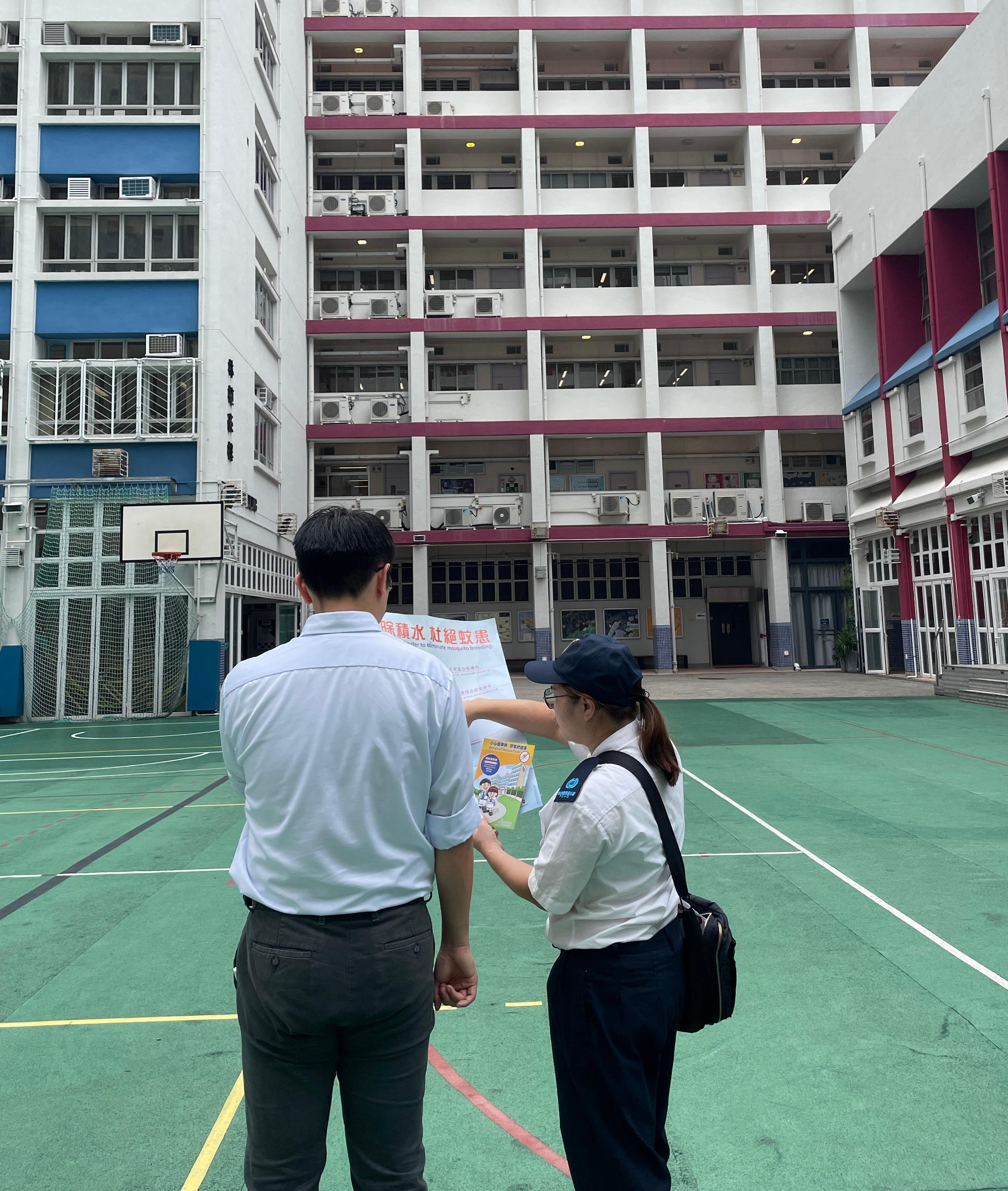 The Food and Environmental Hygiene Department (FEHD) today (April 30) released the fifth batch of gravidtrap indexes and density indexes for Aedes albopictus in April, covering 39 survey areas. Photo shows an FEHD staff member inspecting a school in Shau Kei Wan, Eastern District, providing the school's staff member with technical advice on mosquito prevention and control.