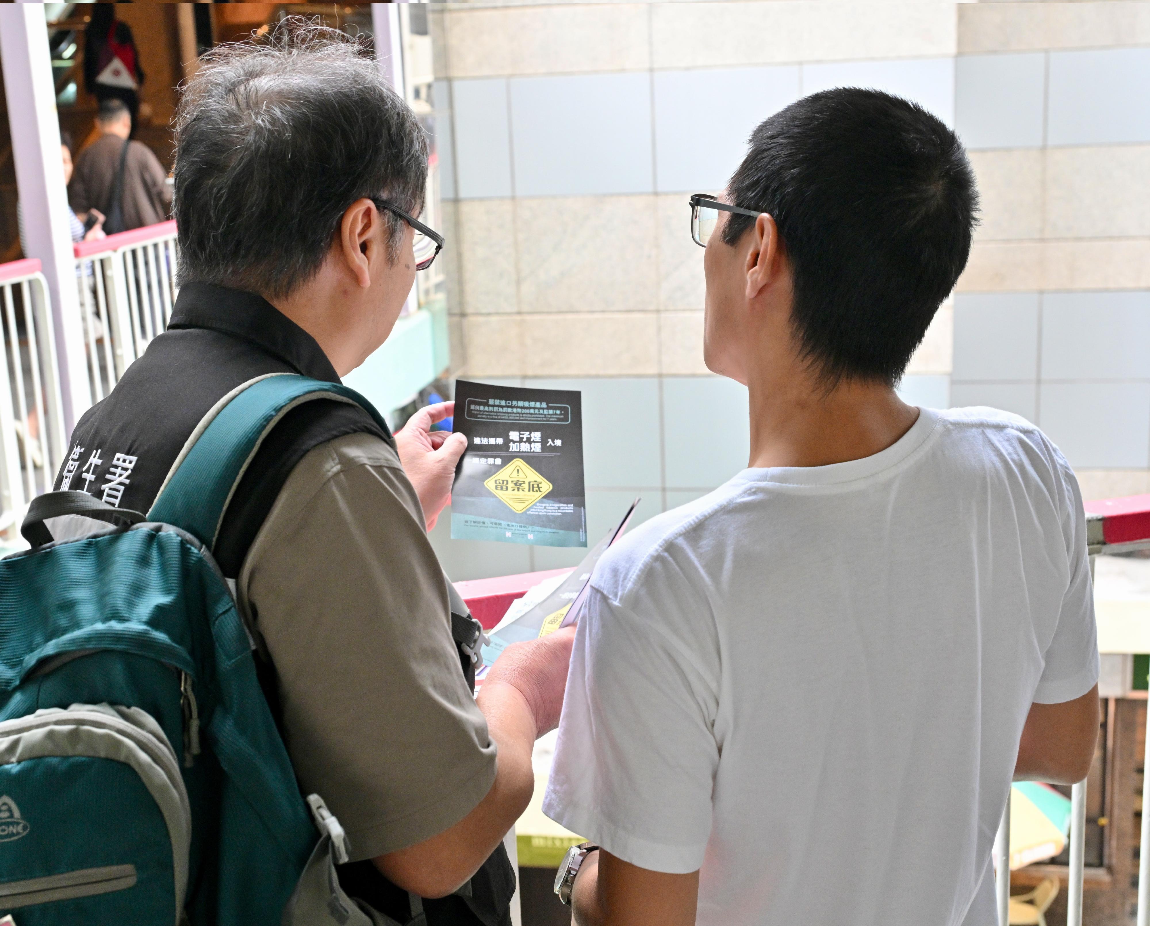 The provision under the Tobacco Control Legislation (Amendment) Ordinance 2025 prohibiting the possession of specified alternative smoking products, such as e-cigarette capsules and heat sticks, in public places takes effect today (April 30). Photo shows an officer from the Tobacco and Alcohol Control Office distributing leaflets in Admiralty to remind members of the public and visitors of the ban today.