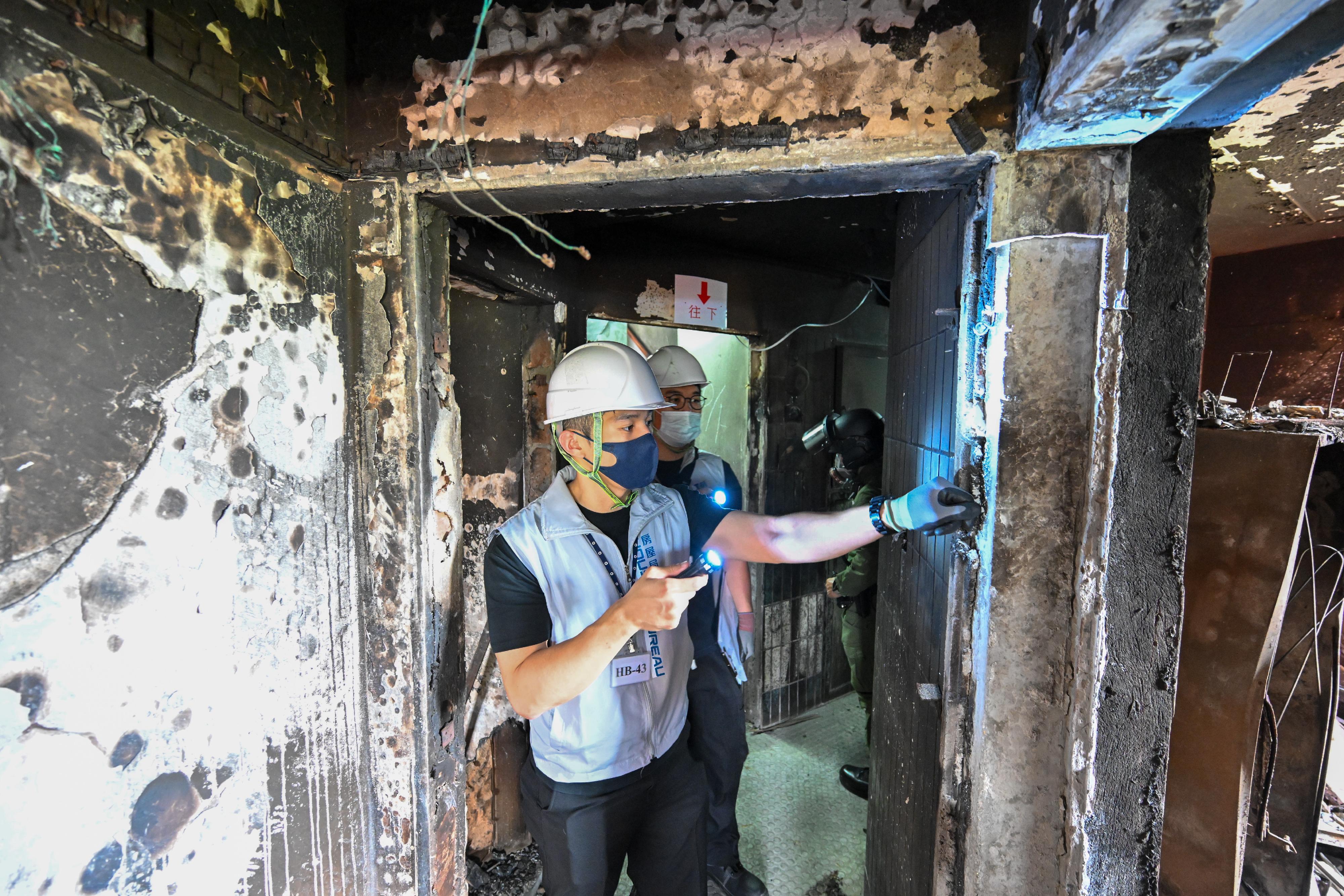 The Housing Bureau and the Housing Department attach great importance to the arrangements for residents of Wang Fuk Court in Tai Po returning to their units. To ensure a safe and smooth process, engineers are stationed on the building floors to provide residents with immediate on-site assistance anytime. Prior to residents' return, the team also conducts a thorough inspection of all floors to check the safety of flat entrance doors, temporary supports and window safety nets. The team also ensures that corridors are cleared of miscellaneous items, directions are clearly marked, and temporary lighting and washrooms are operating properly. Photo shows engineers of the Housing Bureau carefully inspecting the corridor wall of the building before residents return, to ensure that no sharp objects are exposed.