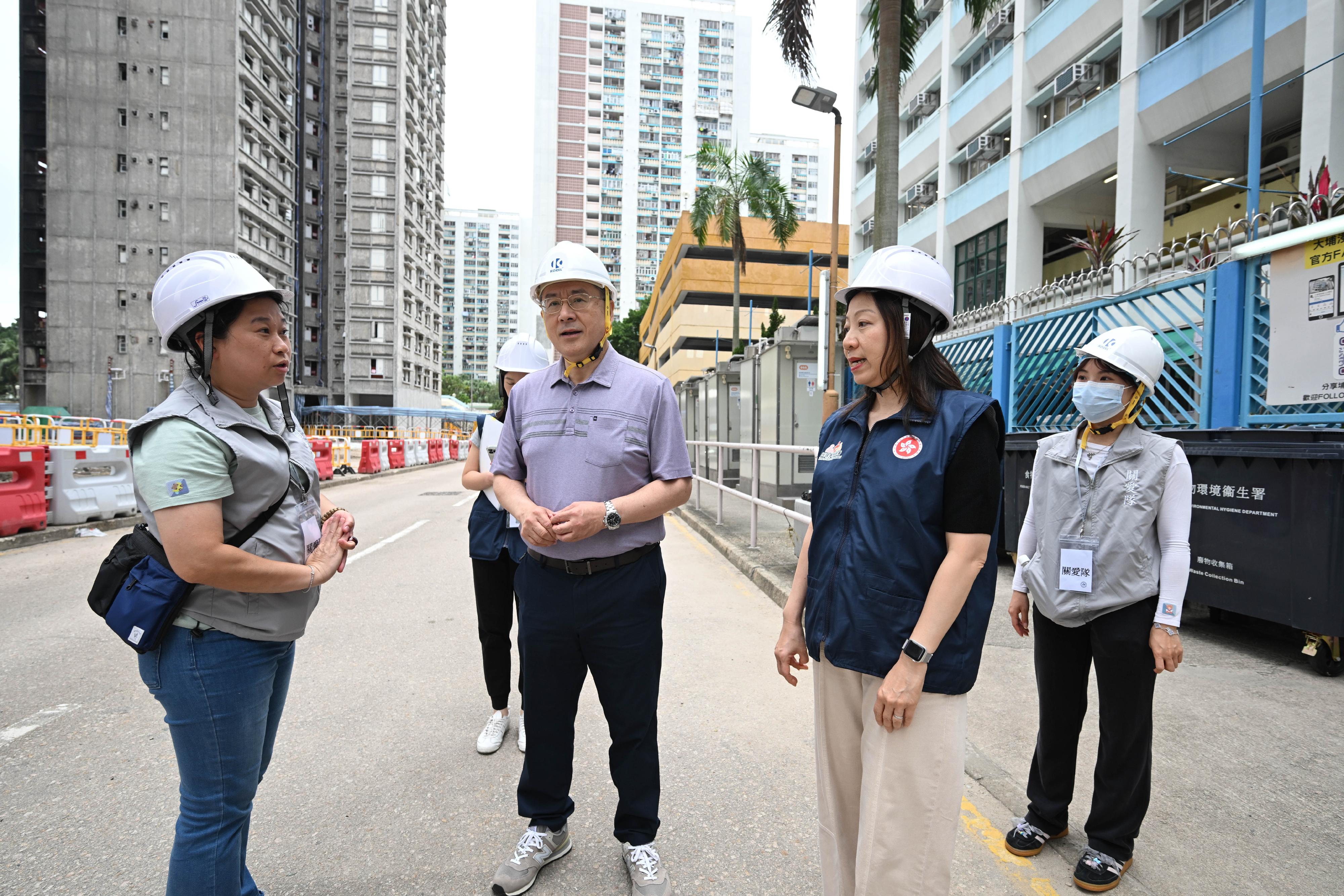 政務司副司長卓永興（左二）今日（五月一日）到大埔宏福苑視察上樓安排，並與地區服務及關愛隊伍義工交談。旁為民政事務總署署長杜潔麗（右二）。