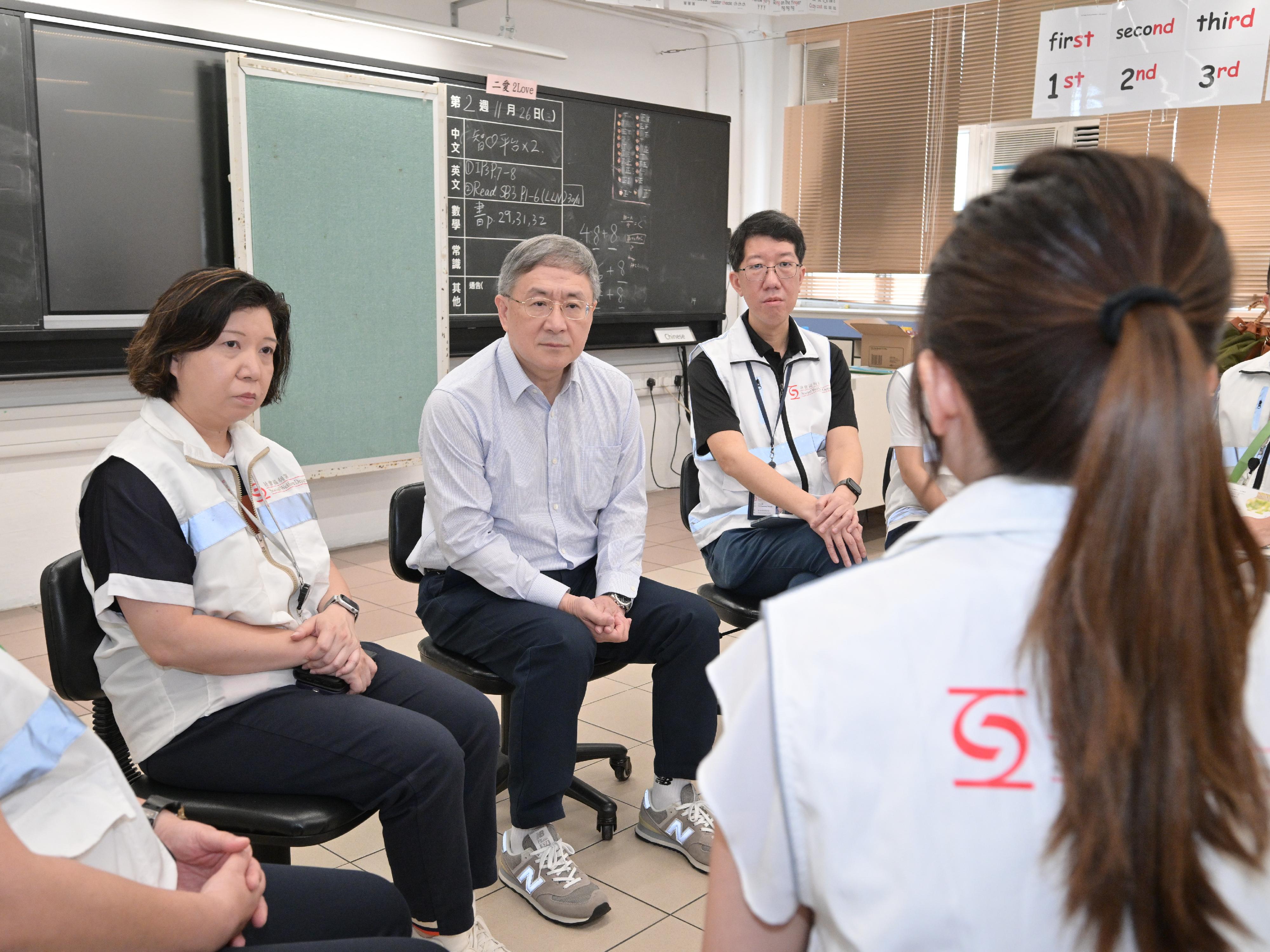 The Deputy Chief Secretary for Administration, Mr Cheuk Wing-hing, today (May 3) inspected the arrangements for residents of Wang Fuk Court in Tai Po returning to their units. He met with social workers under the "one social worker per household" service of the Social Welfare Department (SWD), as well as with dedicated teams formed by social workers and clinical psychologists stationed on different floors. Mr Cheuk learned about various support they provided to the residents since the fire and during the residents' returning to their units, as well as the touching moments during the work. He expressed gratitude to the staff of the SWD for leveraging their enthusiasm and expertise to provide support and counselling to affected residents, and call on them to continue to render the best support with compassion. Photo shows Mr Cheuk (centre) exchanging with the SWD social workers under the "one social worker per household" service and dedicated teams comprising social workers and clinical psychologists who are stationed on open floors to assist residents. Looking on is the Director of Social Welfare, Mr Edward To (right). 

