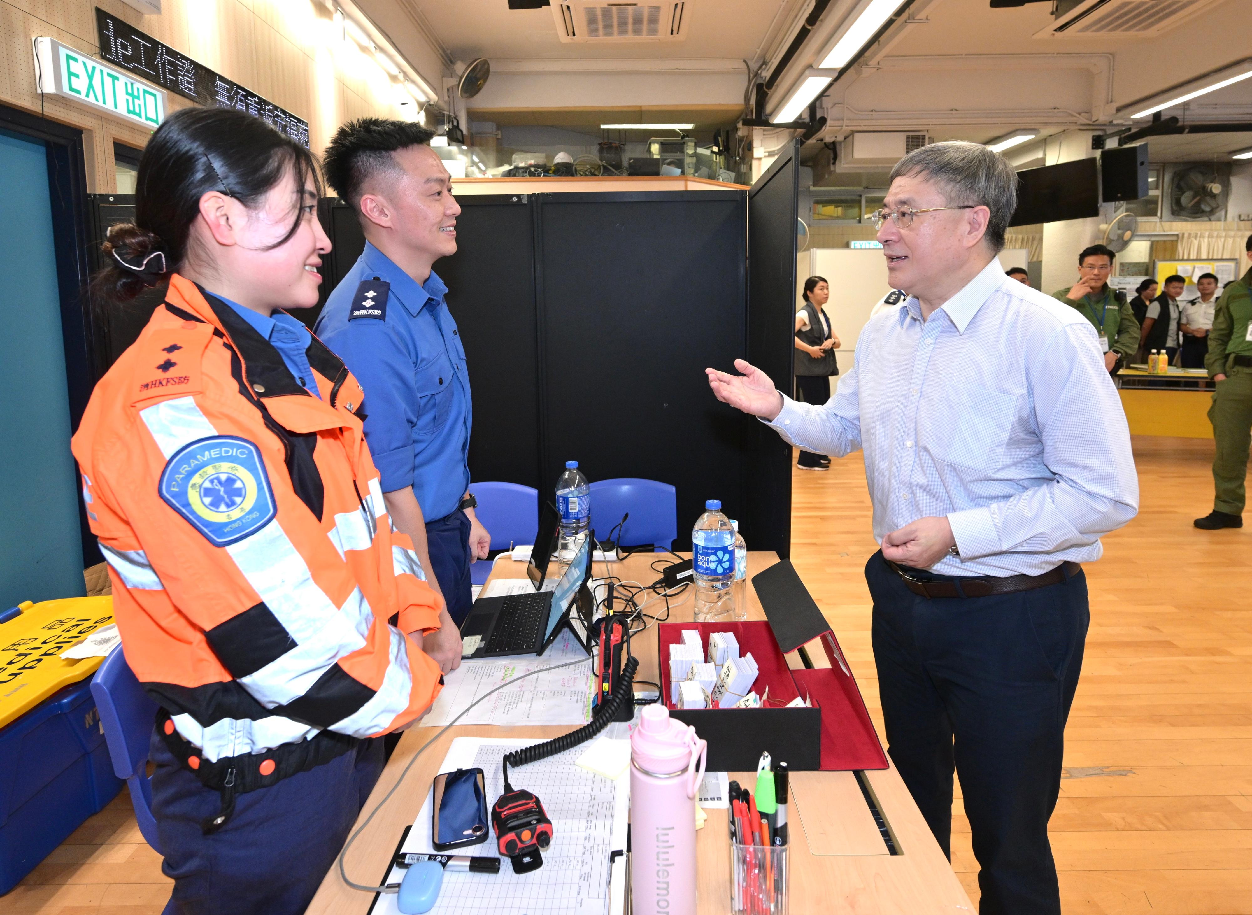 The Deputy Chief Secretary for Administration, Mr Cheuk Wing-hing, today (May 3) inspected the arrangements for residents of Wang Fuk Court in Tai Po returning to their units. He visited the joint command centre to learn about the latest situation and expressed appreciation towards frontline staff. Photo shows Mr Cheuk (right) encouraging the Fire Services Department personnel to continue their efforts and fully assist residents returning to their units.