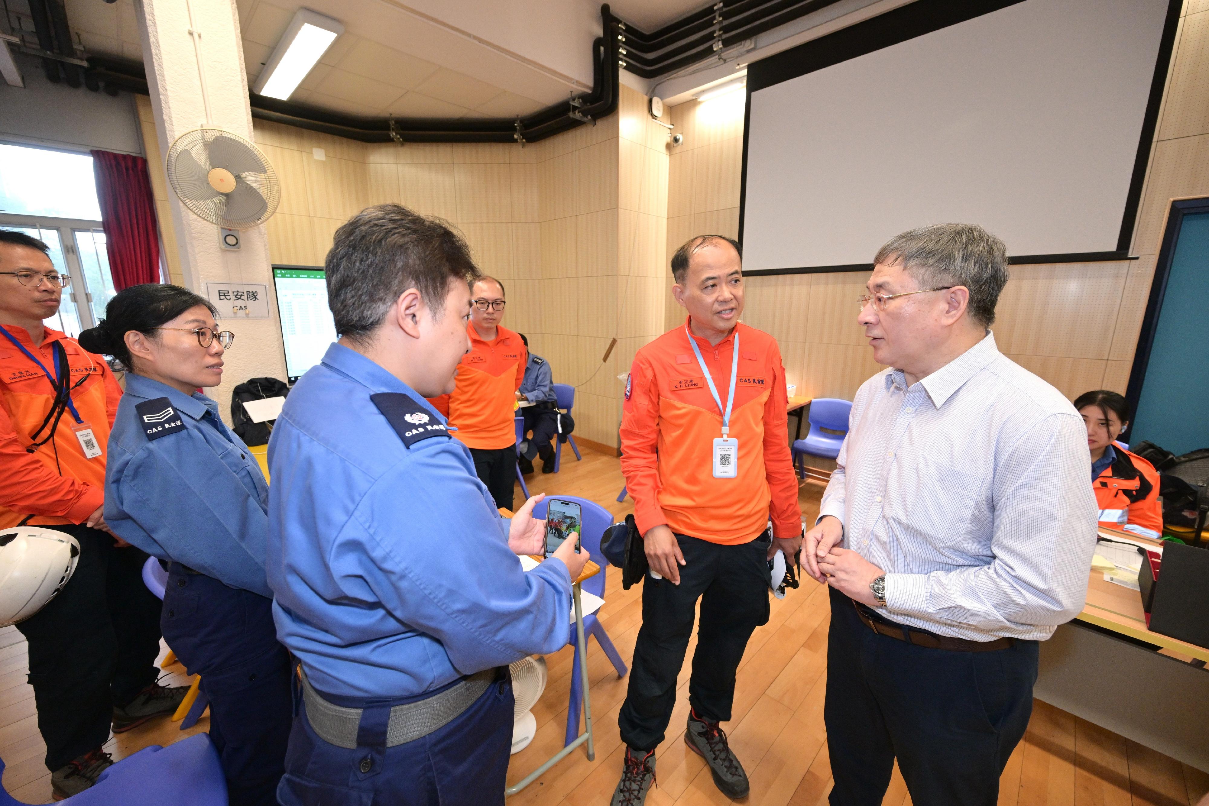 The Deputy Chief Secretary for Administration, Mr Cheuk Wing-hing, today (May 3) inspected the arrangements for residents of Wang Fuk Court in Tai Po returning to their units. He visited the joint command centre to learn about the latest situation and expressed appreciation towards frontline staff. Photo shows Mr Cheuk (first right) encouraging the Civil Aid Service personnel to continue their efforts and fully assist residents returning to their units.