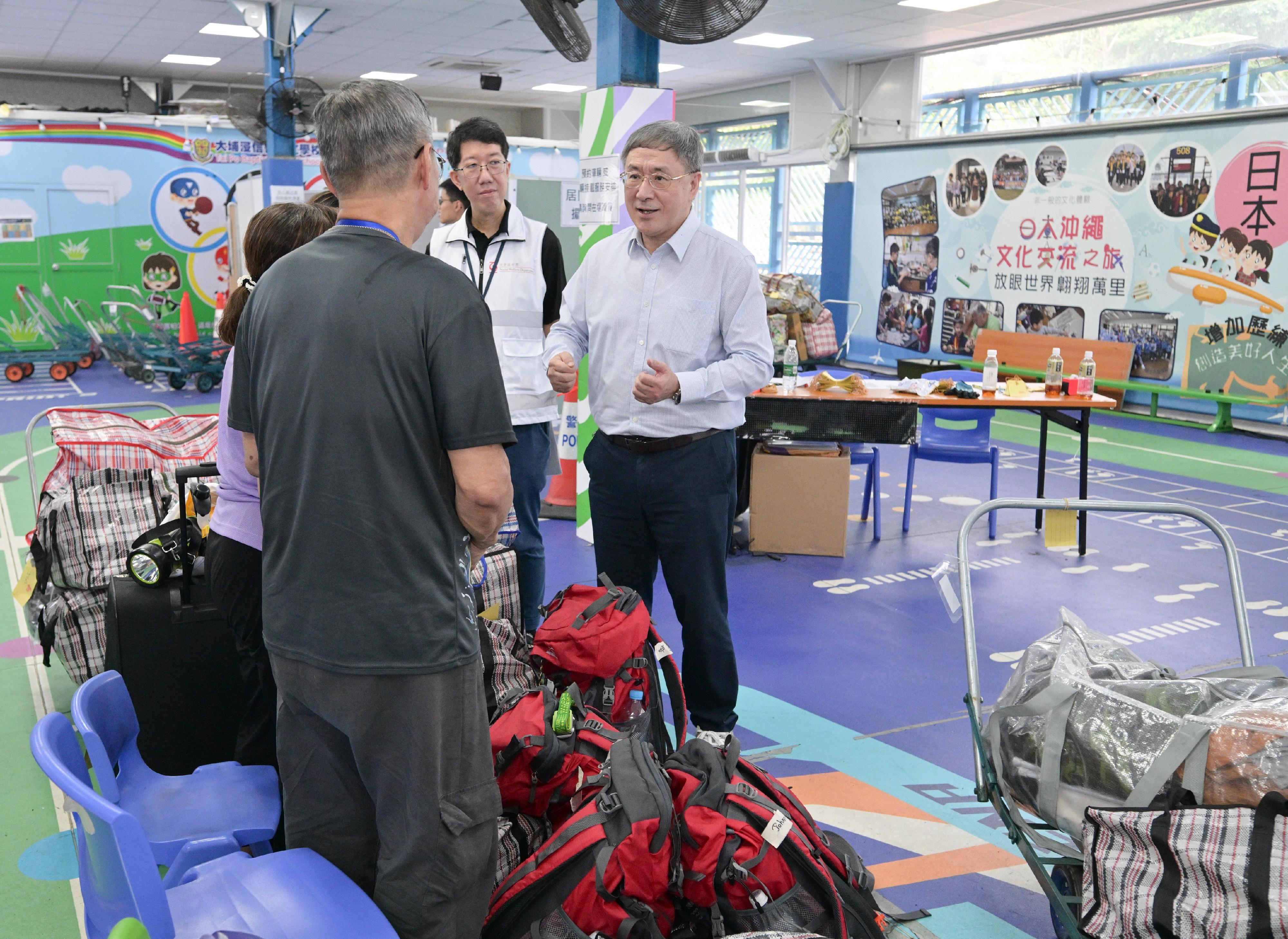 The Deputy Chief Secretary for Administration, Mr Cheuk Wing-hing, today (May 3) visited the resident waiting area set up at Tai Po Baptist Public School and talked with residents of Wang Tai House who are waiting there to transport their belongings. Photo shows Mr Cheuk (right) talking with residents of Wang Tai House.