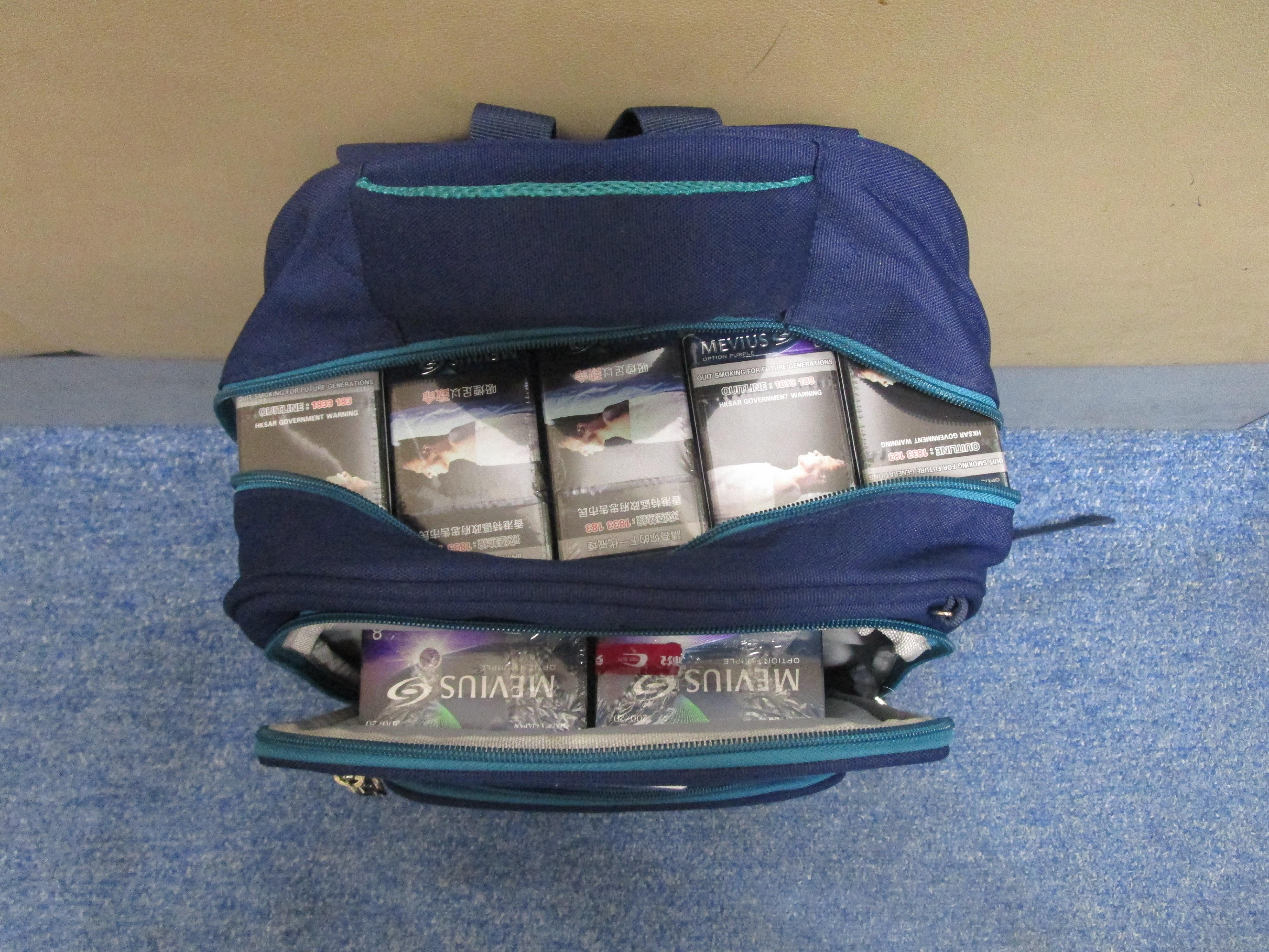 Two incoming passengers were sentenced to four weeks' imprisonment with a fine of $1,000 and eight weeks' imprisonment with a fine of $1,000 respectively by the Fanling Magistrates' Courts today (May 4) for possessing duty-not-paid cigarettes and failing to declare them to Customs officers, in contravention of the Dutiable Commodities Ordinance. Photos show duty-not-paid cigarettes concealed by a 43-year-old incoming male passenger in the backpack carried by his accompanying child.