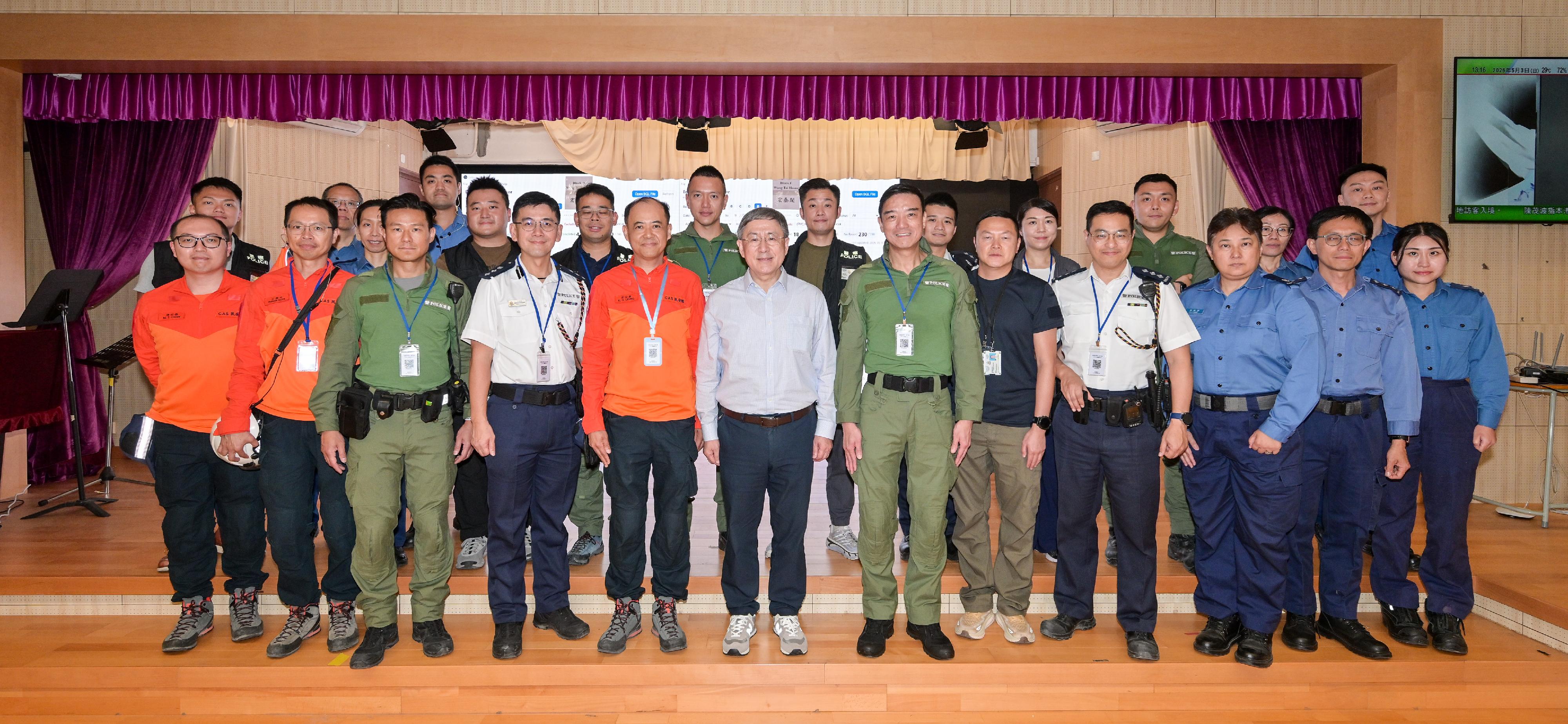 The Deputy Chief Secretary for Administration, Mr Cheuk Wing-hing (front row, sixth left); the Director of Operations of Hong Kong Police Force, Mr Lui Kam-ho (front row, sixth right); and the Chief Staff Officer of the Civil Aid Service (CAS), Mr Leung Kwun-hong (front row, fifth left), are pictured with police officers and CAS members responsible for the arrangements for residents to return to their units.