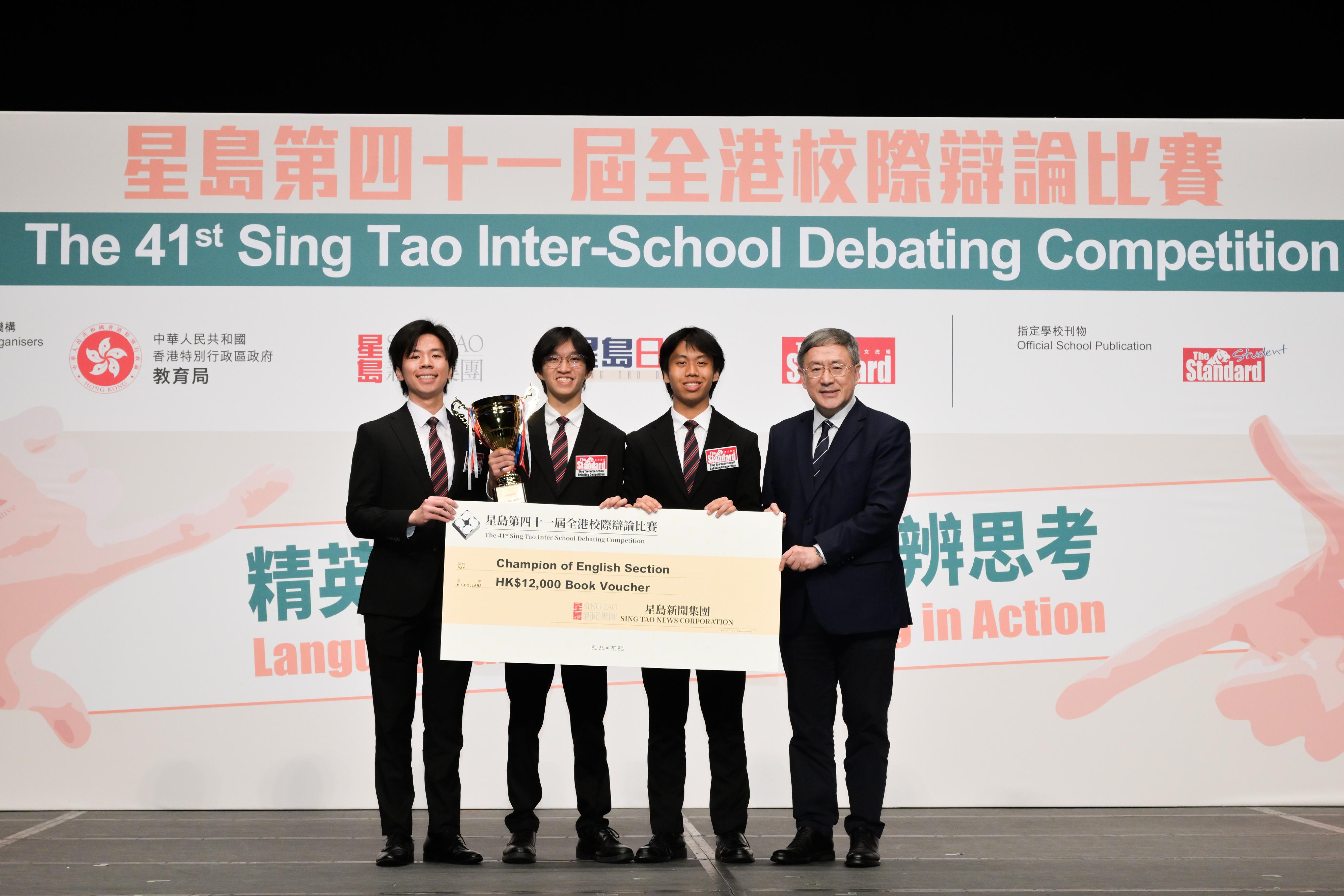 政務司副司長卓永興今日（五月五日）出席星島第四十一屆全港校際辯論比賽總決賽暨頒獎禮。圖示卓永興（右一）在頒獎禮上頒獎予英文組冠軍隊伍拔萃男書院代表。