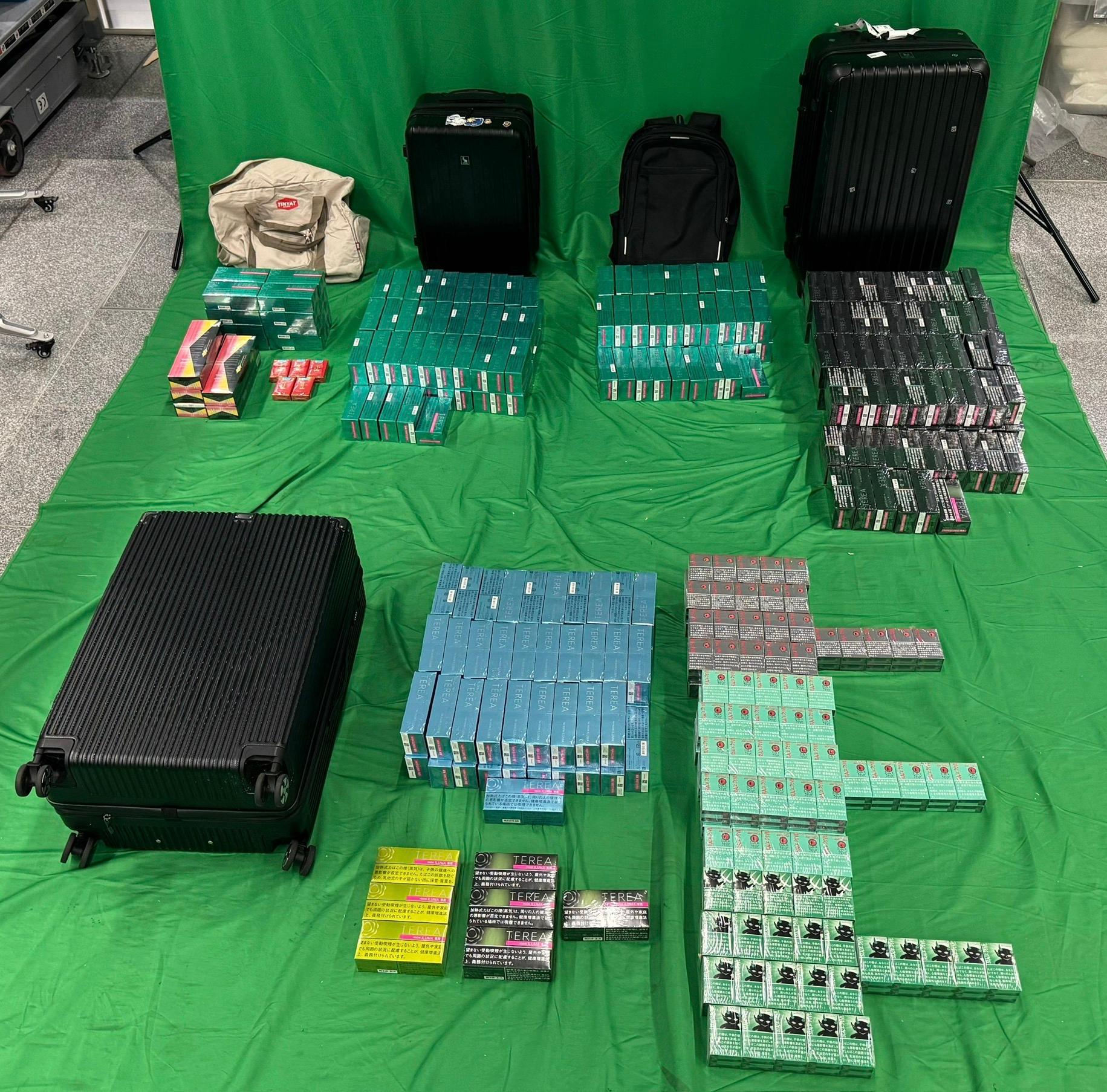 Three incoming passengers were sentenced to between three to six months' imprisonment and fined $1,000 by the West Kowloon Magistrates' Courts yesterday (May 4) and today (May 5) for importing duty-not-paid cigarettes and failing to declare them to Customs officers, as well as for importing alternative smoking products, in contravention of the Dutiable Commodities Ordinance and the Import and Export Ordinance. Photo shows the duty-not-paid cigarettes and the alternative smoking products seized from the personal baggage of the 34-year-old incoming male passenger.