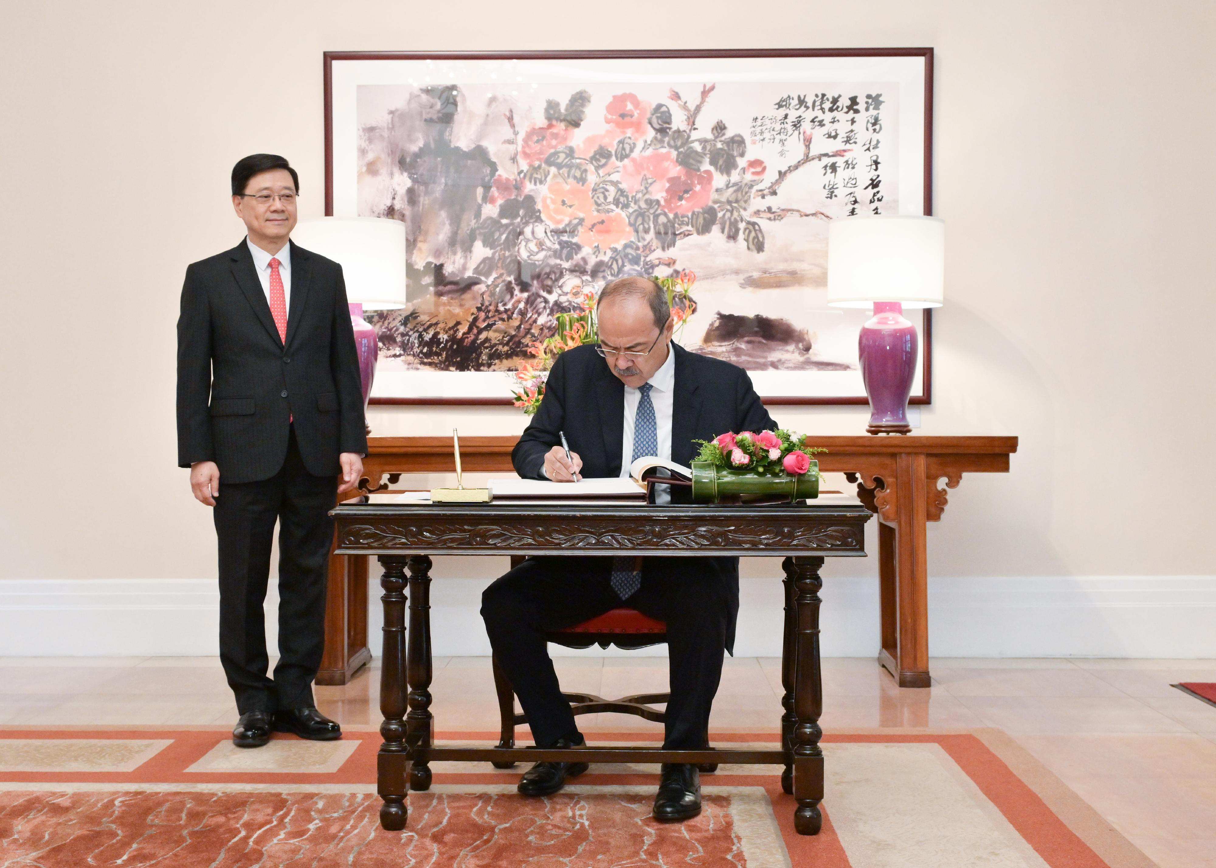 The Chief Executive, Mr John Lee (left), met with the visiting Prime Minister of Uzbekistan, Mr Abdulla Nigmatovich Aripov (right), at Government House today (May 6). Photo shows Mr Aripov signing the guest book at Government House.