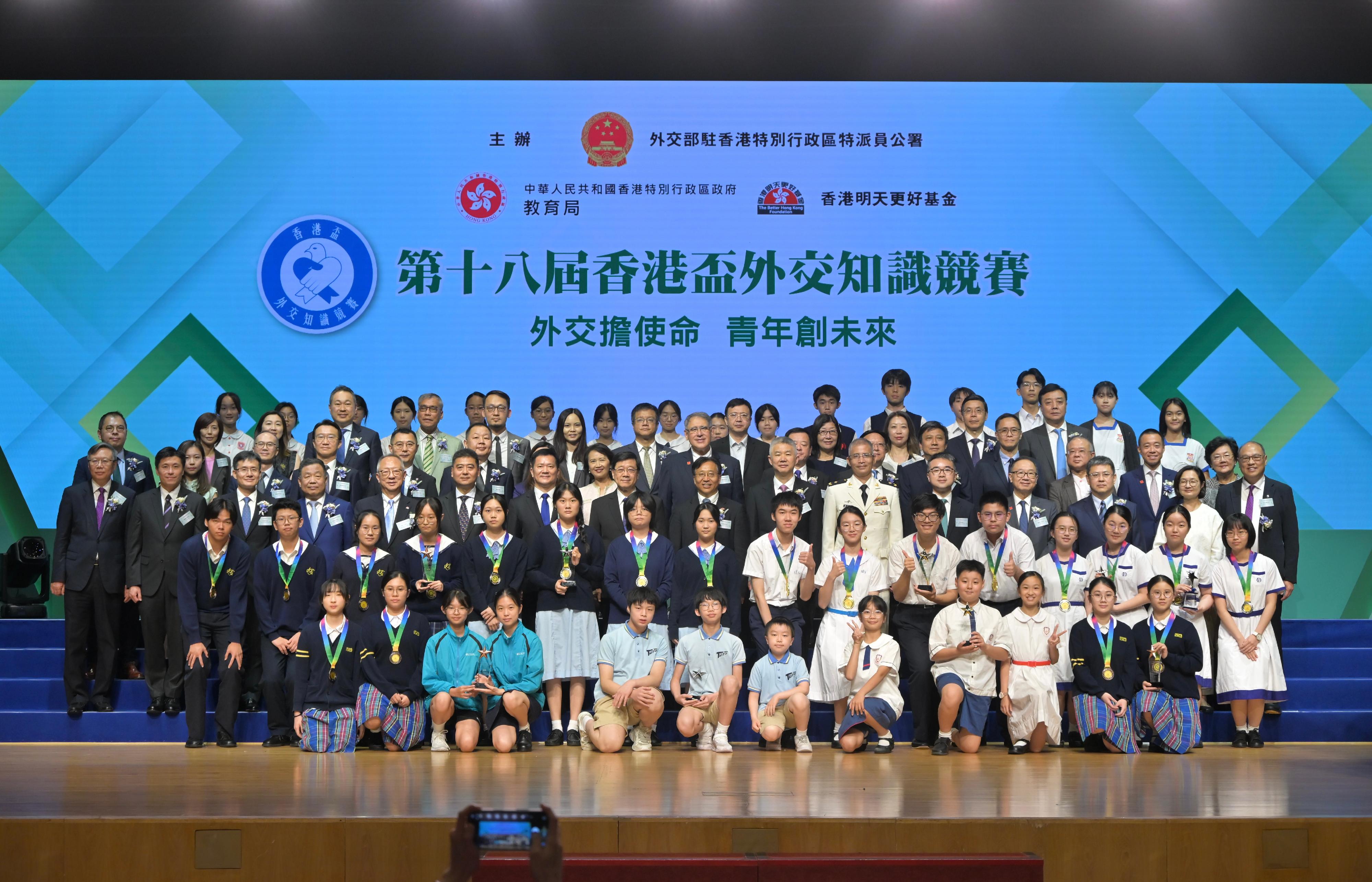 行政長官李家超今日（五月九日）出席第十八屆香港盃外交知識競賽決賽暨頒獎典禮。圖示李家超（第三排左八）、中華人民共和國外交部駐香港特別行政區特派員公署特派員崔建春（第三排右八）、中央人民政府駐香港特別行政區聯絡辦公室副主任孫尚武（第三排右七）、中央人民政府駐香港特別行政區維護國家安全公署副署長陳楓（第三排左七）、中國人民解放軍駐香港部隊副司令員譚志偉（第三排右六）、教育局副局長施俊輝博士（第三排右五）、政府新聞處處長謝振中（第三排左二）、香港明天更好基金公司贊助人鍾志平（第三排左五）和其他嘉賓與得獎者合照。
