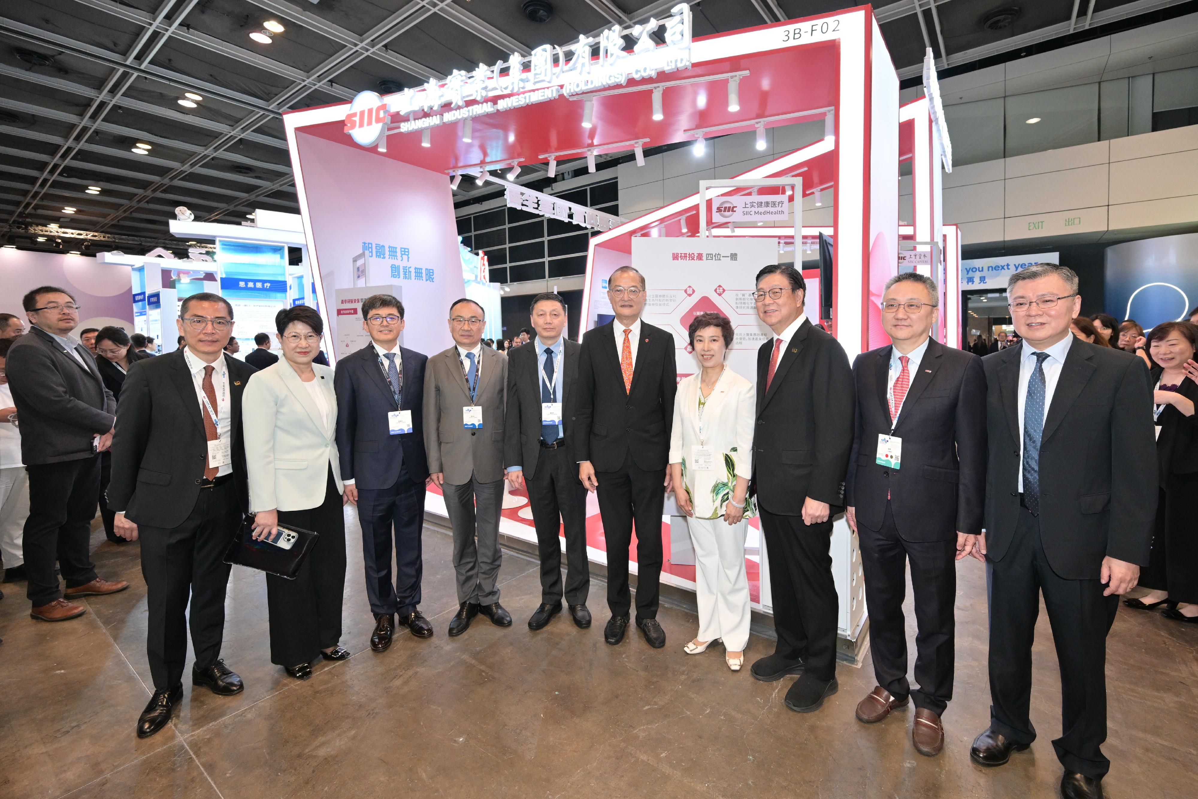 The Secretary for Health, Professor Lo Chung-mau (fifth right), tours an exhibition booth set up at the Asia Summit on Global Health today (May 11).