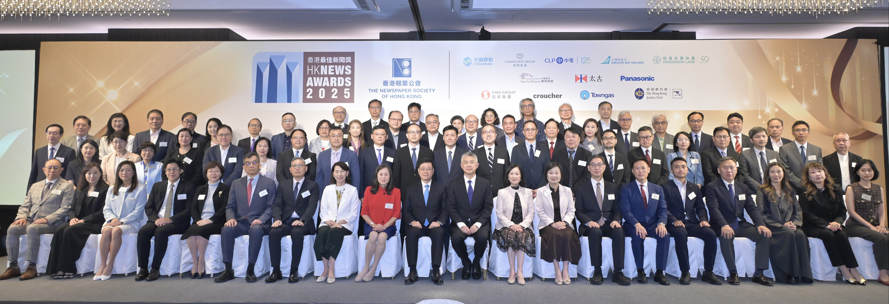 行政長官李家超今日（五月十五日）出席2025年香港最佳新聞獎頒獎典禮暨午宴。圖示（第一排左九起）香港報業公會主席譚衛兒、李家超、中央人民政府駐香港特別行政區聯絡辦公室副主任孫尚武、政府新聞處處長謝振中（第二排左十二），以及其他嘉賓在活動合照。 