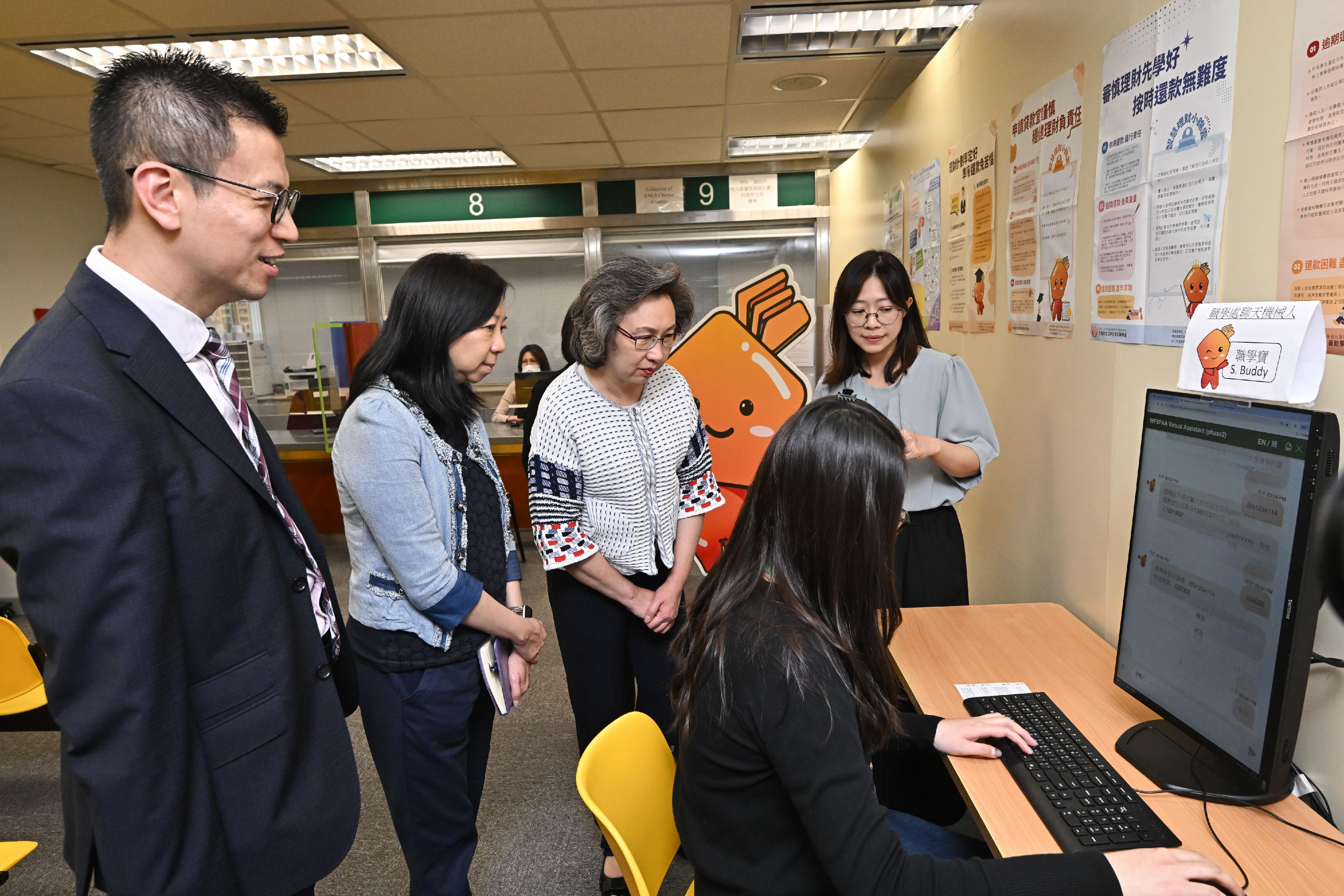 The Secretary for the Civil Service, Mrs Ingrid Yeung, visited the Working Family and Student Financial Assistance Agency (WFSFAA) this afternoon (May 15). Photo shows Mrs Yeung (third left) being briefed by a WFSFAA staff member on the round-the-clock online instant enquiry services provided by the department's AI chatbot mascot S. Buddy. Looking on are the Permanent Secretary for the Civil Service, Ms Shirley Lam (second left), and the Head, WFSFAA, Mr Gilford Law (first left).
