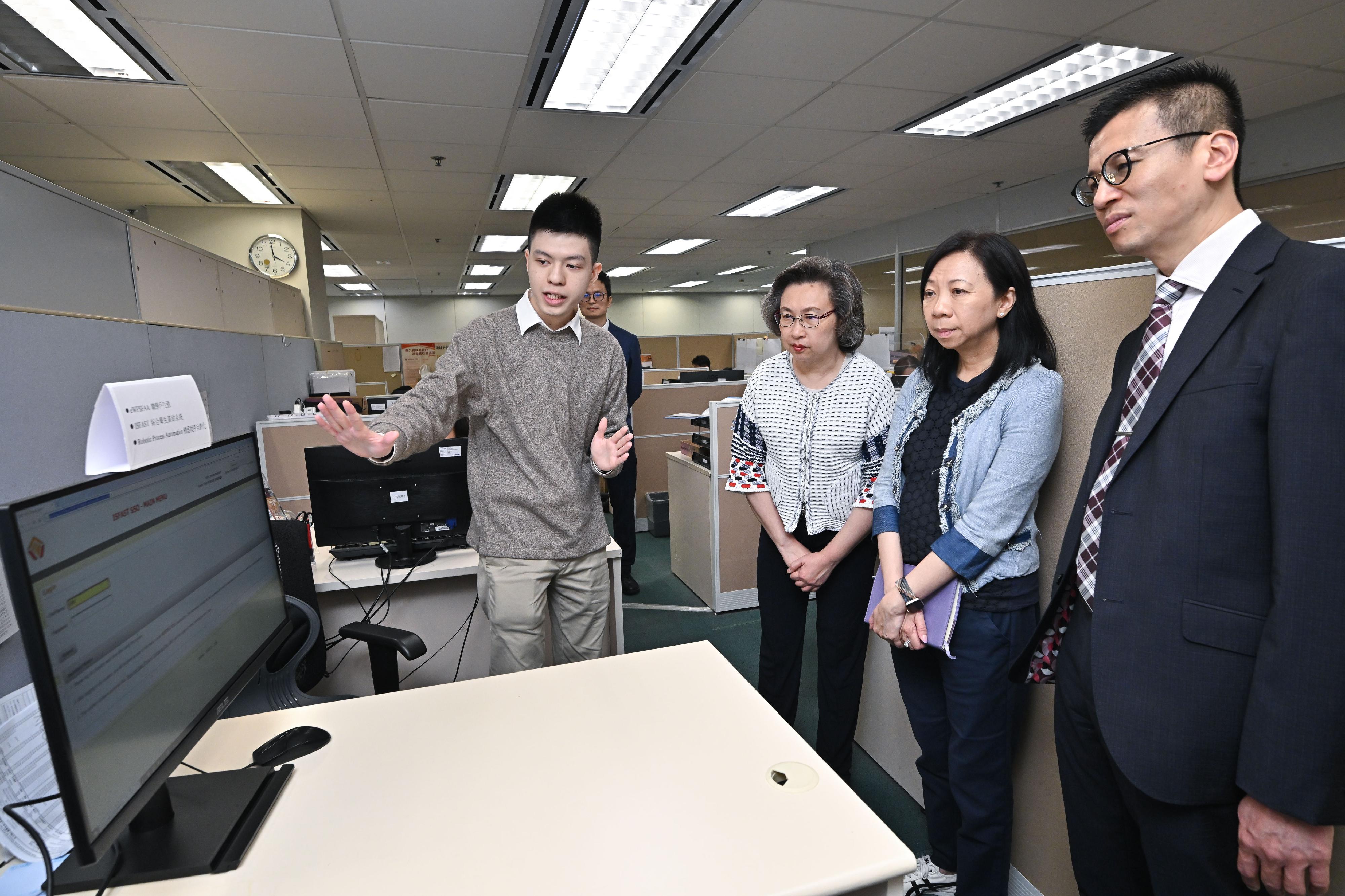 The Secretary for the Civil Service, Mrs Ingrid Yeung, visited the Working Family and Student Financial Assistance Agency (WFSFAA) this afternoon (May 15). Photo shows a WFSFAA staff member demostrating to Mrs Yeung (second left) the use of an in-house developing computer programme to automate repetitive and simple workflows to save the manual data entry process. Looking on are the Permanent Secretary for the Civil Service, Ms Shirley Lam (second right), and the Head , WFSFAA, Mr Gilford Law (first right).