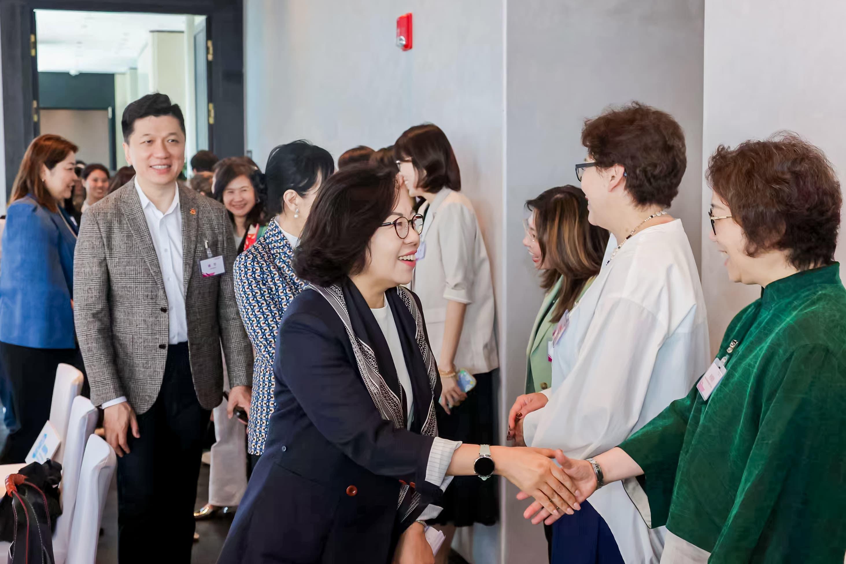The Secretary for Home and Youth Affairs, Miss Alice Mak, after attending the Asia-Pacific Economic Cooperation Women and the Economy Forum yesterday, conducted visits with other delegates to learn about the latest efforts in promoting women's development in Shanghai today (May 16). Photo shows Miss Mak (second left), interacting with Hong Kong women and youth in Shanghai.