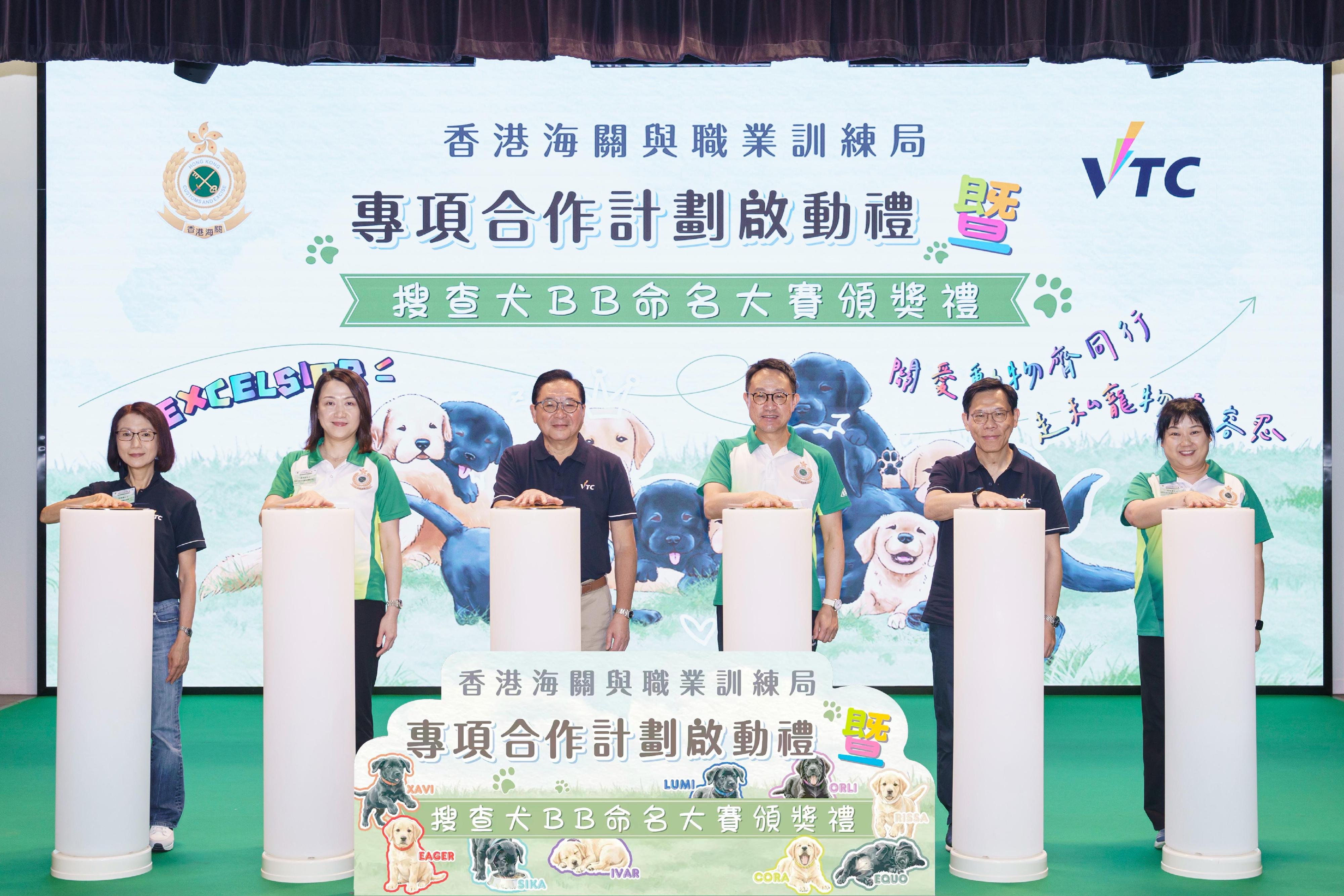 香港海關與職業訓練局今日(五月十六日)於香港專業教育學院(葵涌)舉行香港海關與職業訓練局專項合作計劃啟動禮暨搜查犬BB命名大賽頒奬禮。圖示職業訓練局主席林健鋒(左三)、海關關長陳子達(右三)與其他海關人員及職業訓練局人員進行啟動儀式。