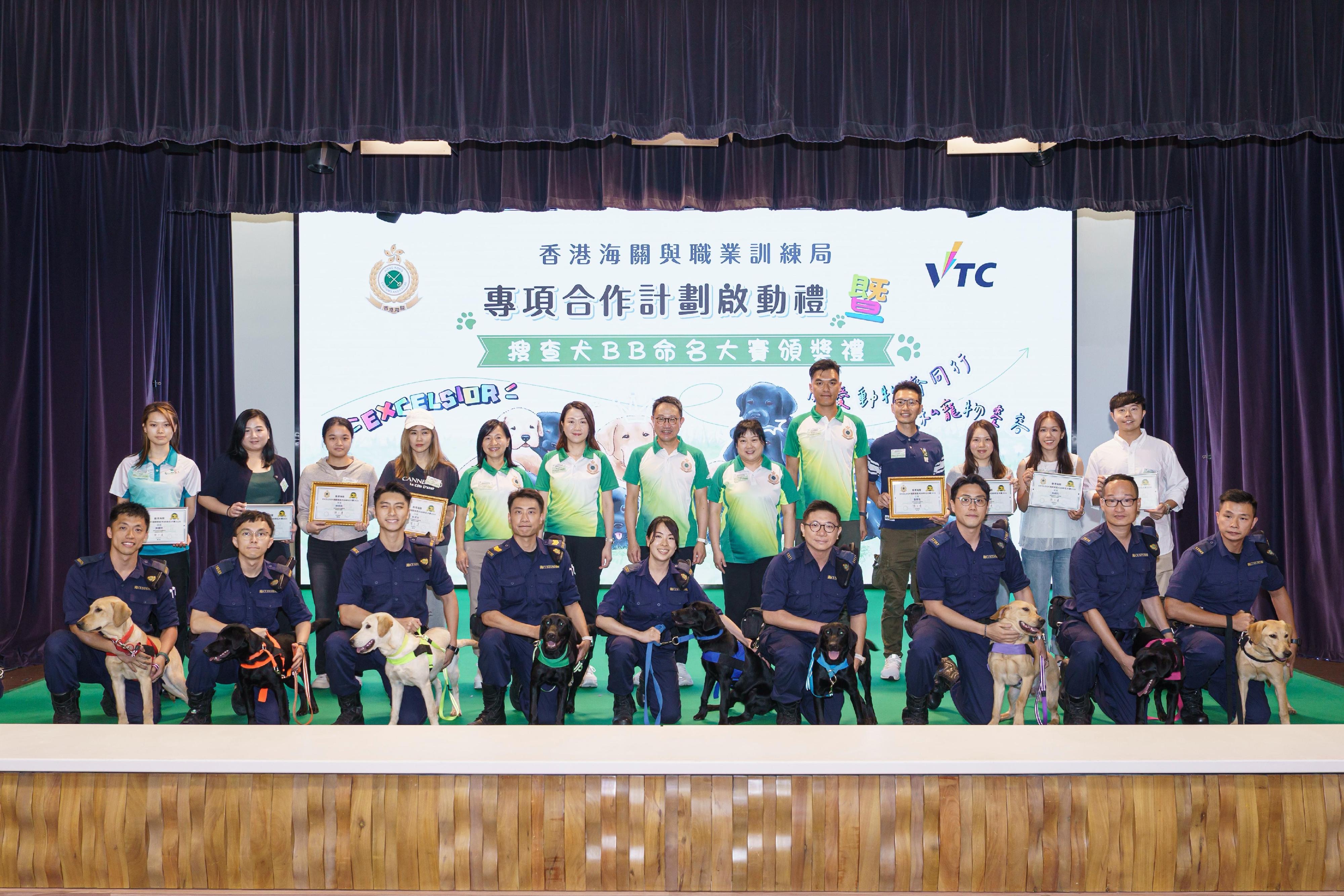 香港海關與職業訓練局今日(五月十六日)於香港專業教育學院(葵涌)舉行香港海關與職業訓練局專項合作計劃啟動禮暨搜查犬BB命名大賽頒奬禮。圖示海關關長陳子達(後排中)與其他海關人員及搜查犬BB命名大賽得獎者合照。
