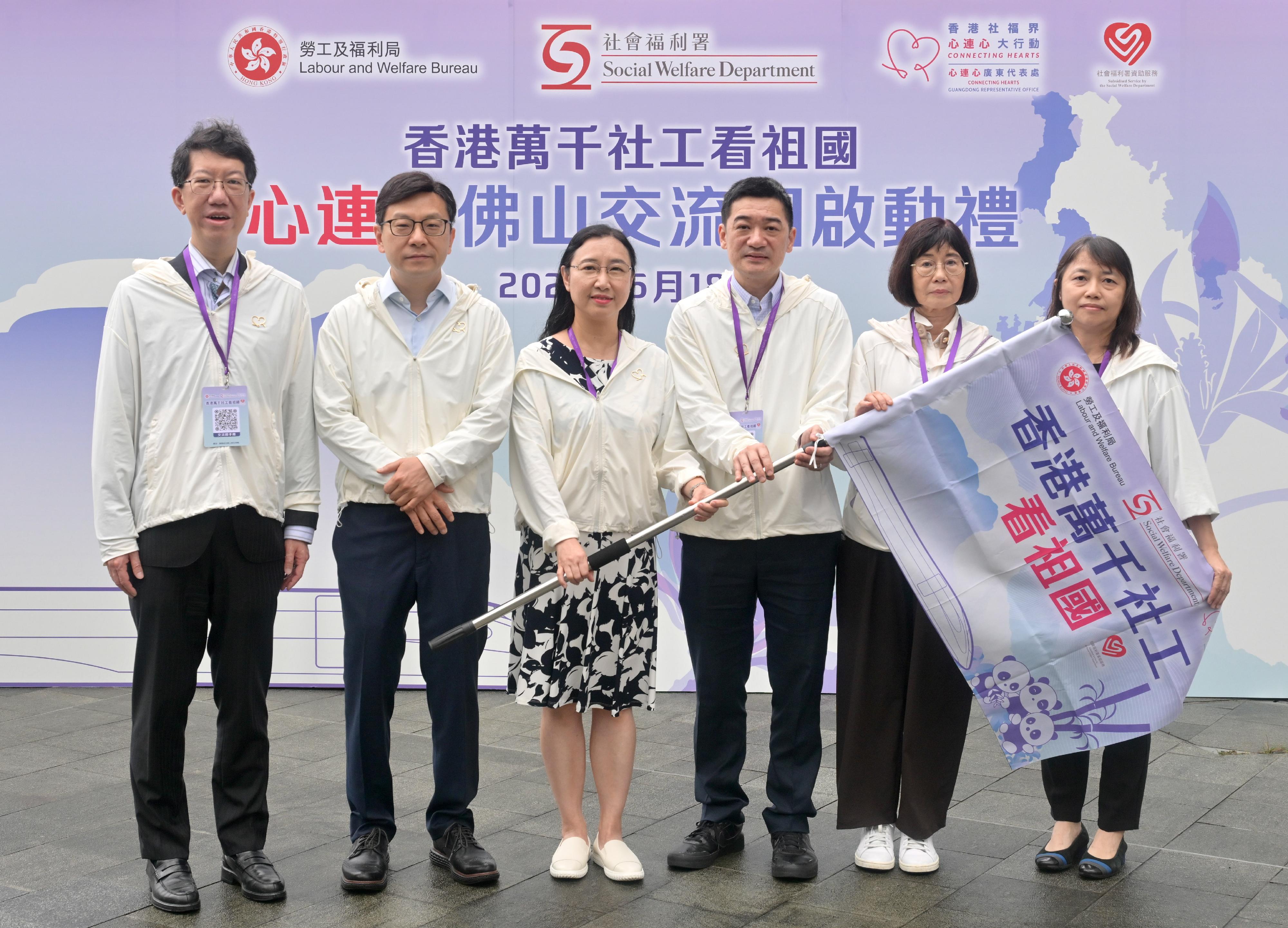 勞工及福利局局長孫玉菡今日(五月十八日)為香港萬千社工看祖國——「心連心」佛山高鐵交流團啟動禮主禮。圖示孫玉菡(左二)及社會福利署(社署)署長杜永恒(左一)授旗予勞工及福利局常任秘書長劉焱(左三)、中央人民政府駐香港特別行政區聯絡辦公室社會工作部處長陳子明(右三)、香港社福界心連心大行動副主席、心連心學院院長譚贛蘭教授(右二)及社署副署長(行政)關淑儀(右一)。
