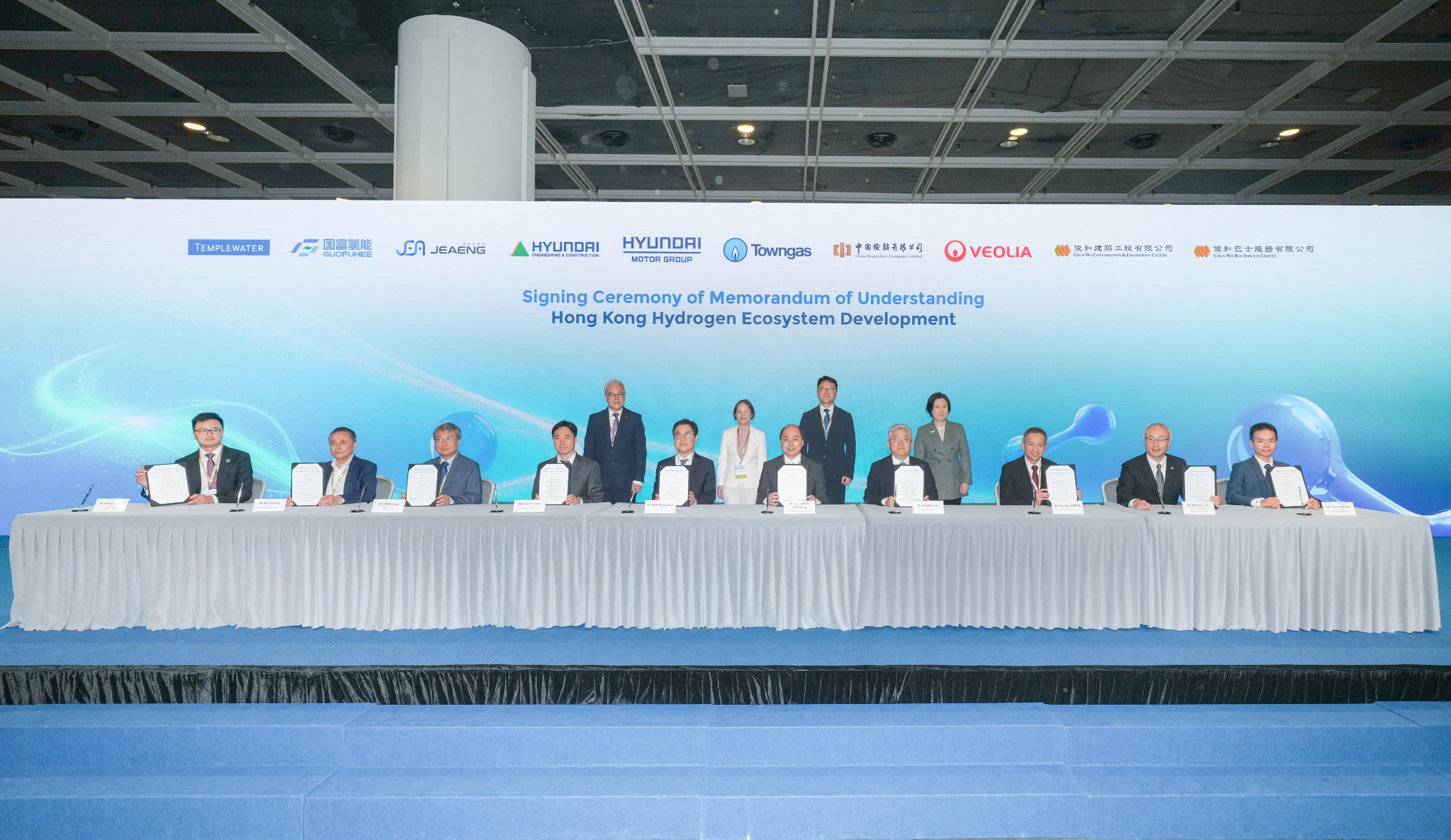 國際氫能發展論壇2026今日(五月十八日)於香港會議展覽中心舉行開幕禮。圖示十間內地、香港及韓國企業的代表在署理環境及生態局局長黃淑嫻(後排左二)、機電工程署署長潘國英(後排左一)、投資推廣署署長劉凱旋(後排右一)和韓國國土交通部國土都市室室長Jeong Eui-kyung(後排右二)見證下,簽署諒解備忘錄,合作在香港發展氫能業務,促進氫能供應鏈的區域整合。