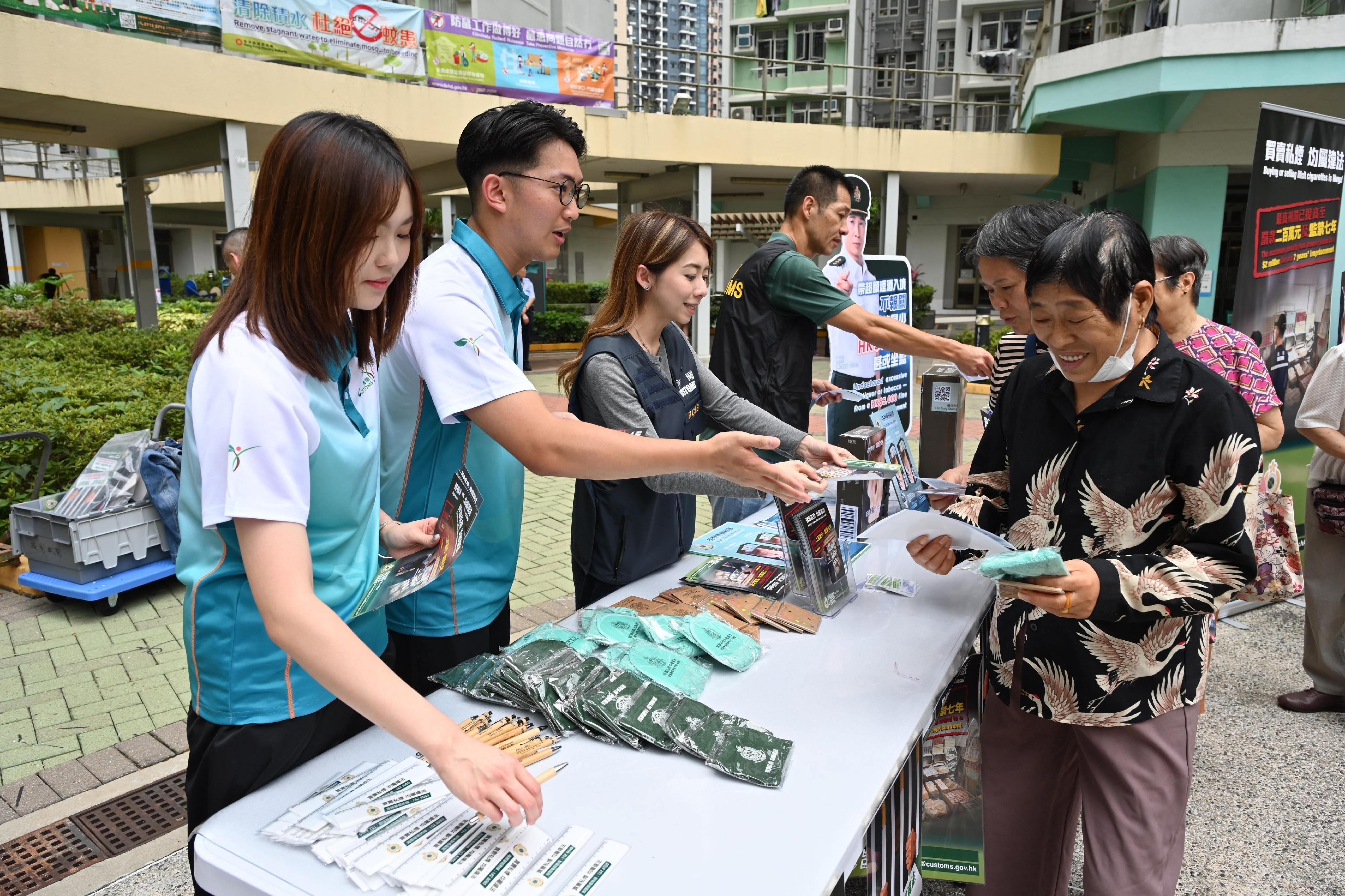 香港海關今日（五月二十日）與區議員、衞生署控煙酒辦公室、警務處及房屋署在啟德德朗邨進行聯合反私煙宣傳活動，並講解完稅標籤制度。「香港海關青年發展計劃」（Customs YES）會員亦有參與是次活動。圖示海關人員聯同Customs YES會員向居民宣揚反私煙信息。