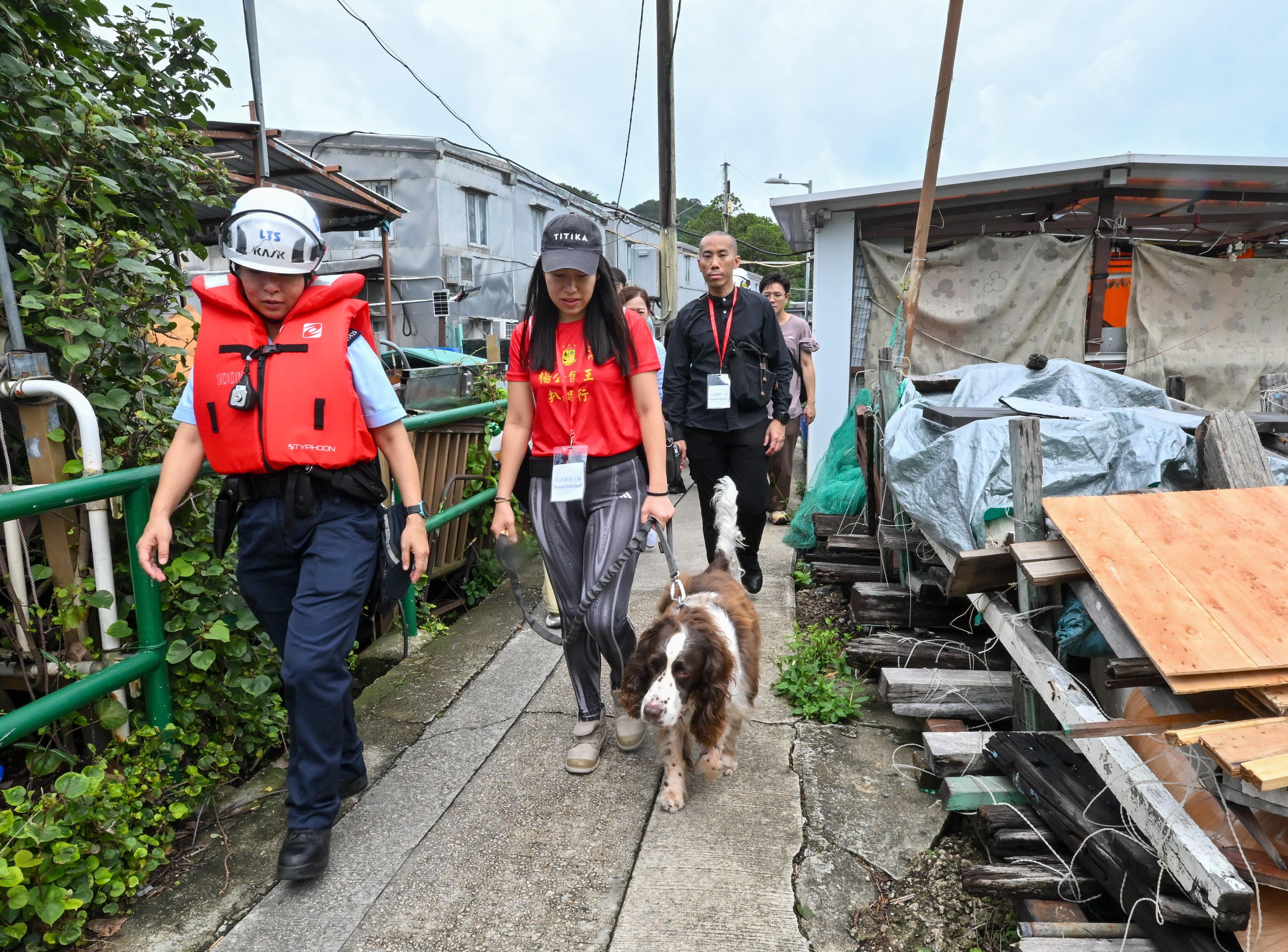 The Islands District Office conducted an interdepartmental rescue and evacuation drill in the event of flooding in Tai O today (May 20). Photo shows a police officer assisting trapped residents to evacuate during the drill.
