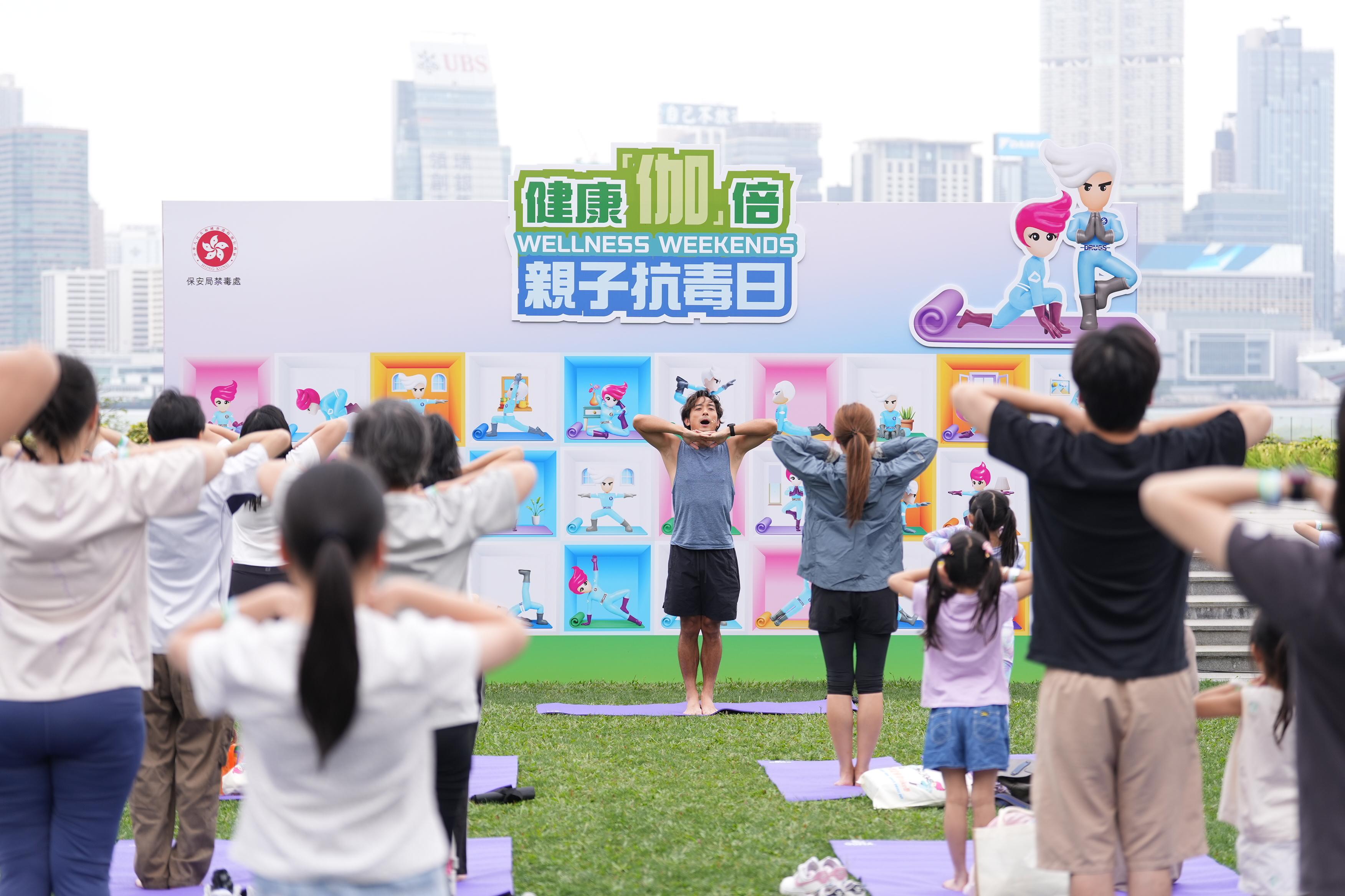 由保安局禁毒處舉辦的「健康『伽』倍 親子抗毒日」共設三站、合共六場親子瑜伽工作坊,於四月及五月期間先後在啟德車站廣場、添馬公園及荃灣公園舉行。圖示瑜伽導師林德信於添馬公園帶領參加者練習瑜伽。