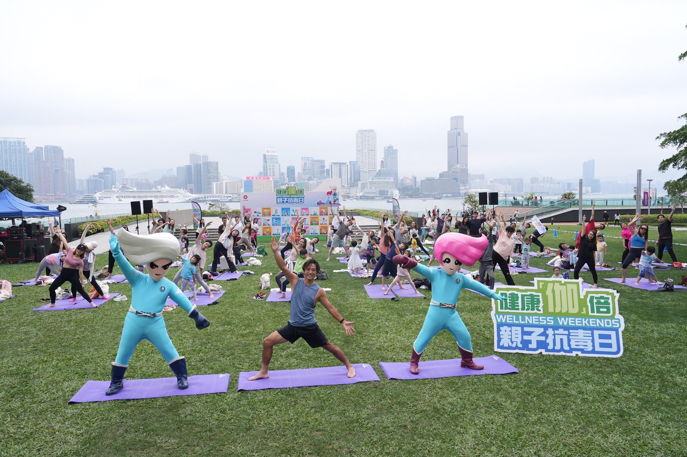 The "Wellness Weekends" organised by the Narcotics Division of the Security Bureau comprised three stops, with six family yoga workshops held in April and May at Kai Tak Station Square, Tamar Park and Tsuen Wan Park. Photo shows yoga tutor Alex Lam finishing the yoga practice with participants at Tamar Park.