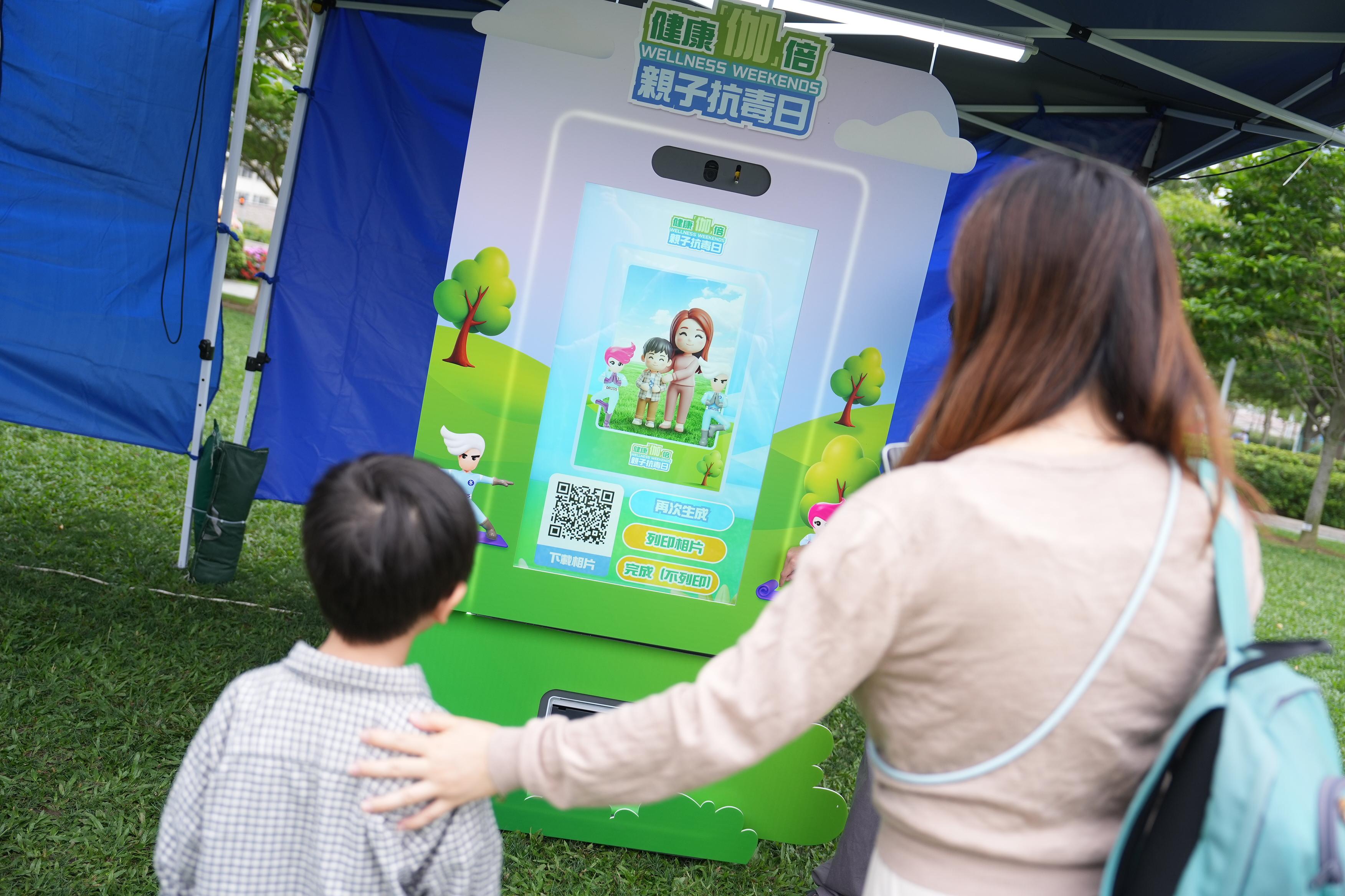 The "Wellness Weekends" organised by the Narcotics Division of the Security Bureau comprised three stops, with six family yoga workshops held in April and May at Kai Tak Station Square, Tamar Park and Tsuen Wan Park. Photo shows the family AI photo booth at the event.