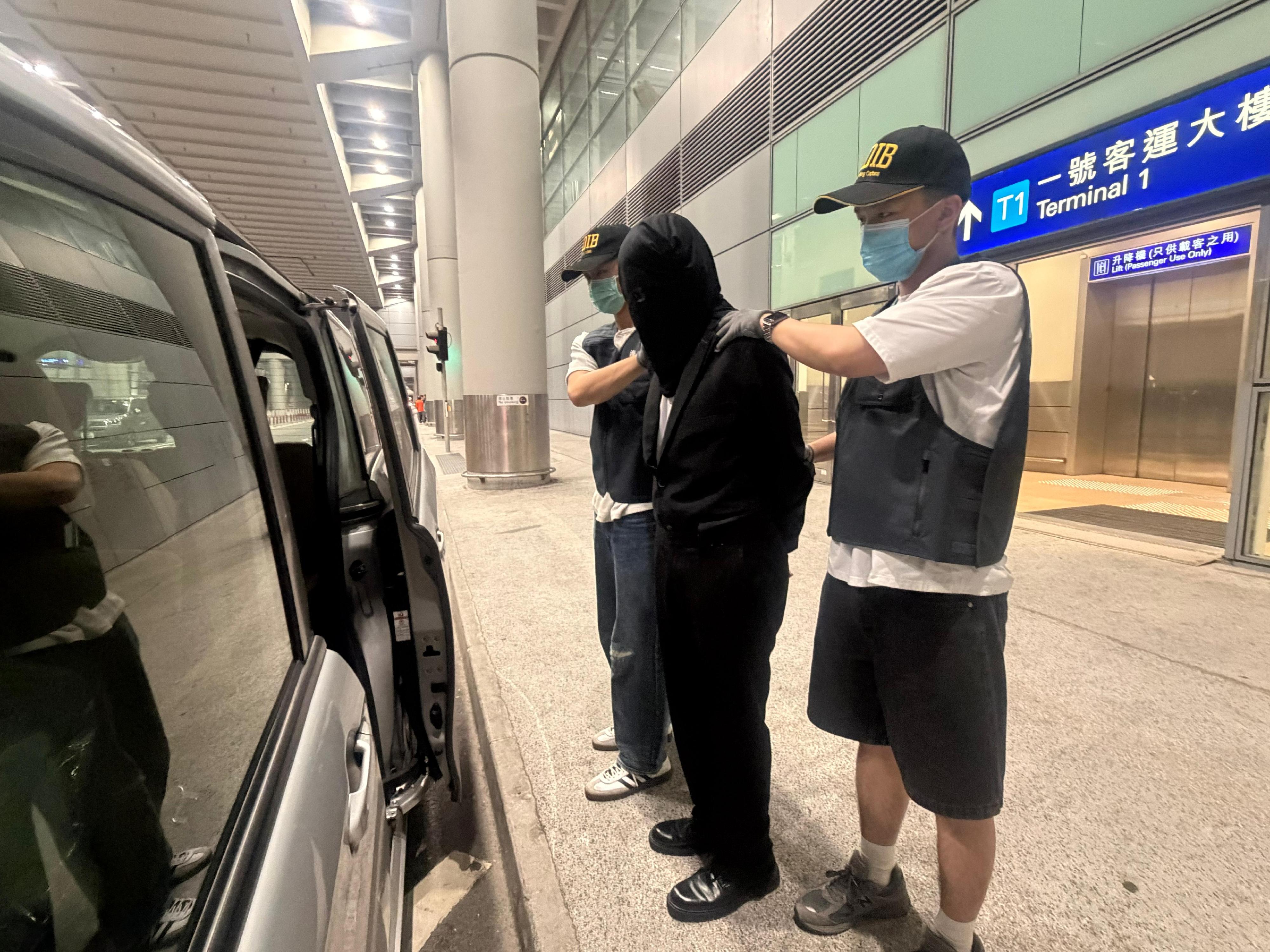 Hong Kong Customs today (May 25) detected a drug trafficking case at Hong Kong International Airport. About 1.9 kilograms of suspected heroin, with an estimated market value of about $1.1 million, and one duty-not-paid cigarette were seized. Photo shows the arrested person (centre) involved in the case.