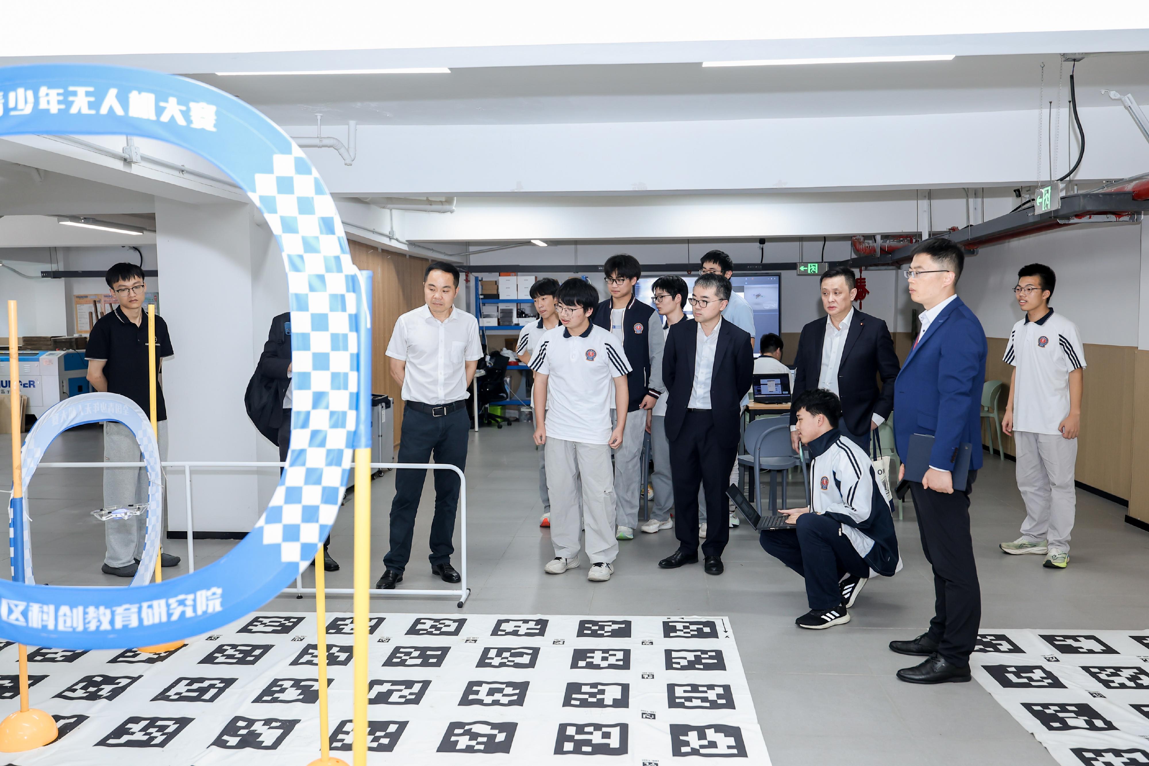 The Under Secretary for Education, Dr Sze Chun-fai, led a delegation to visit Hangzhou, Zhejiang Province, yesterday (May 26). Photo shows Dr Sze (fifth right) and the delegation visiting Hangzhou Pingyao High School, an AI education base in Hangzhou, and experiencing an AI class featuring drones today (May 27).